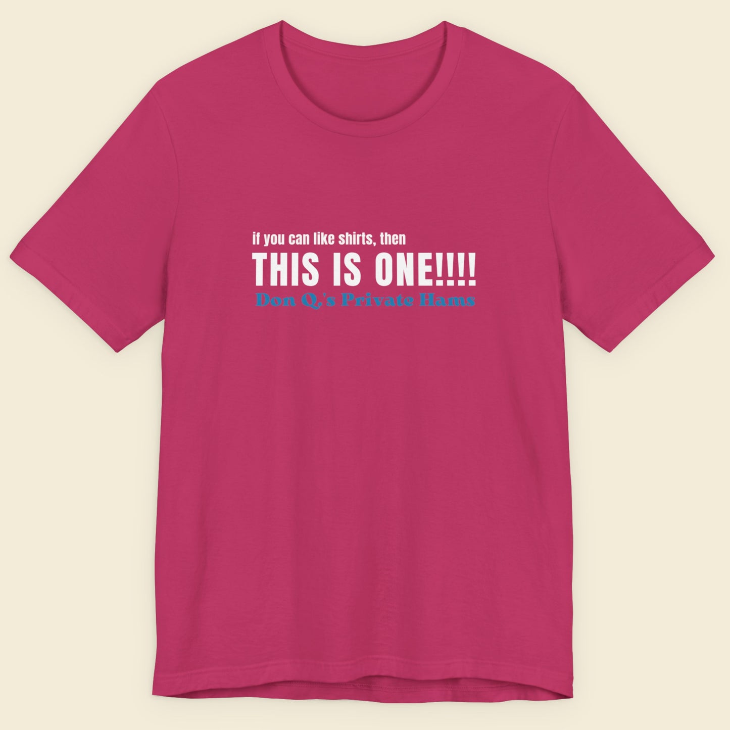 Pink t-shirt with humorous colorful text on a beige background.