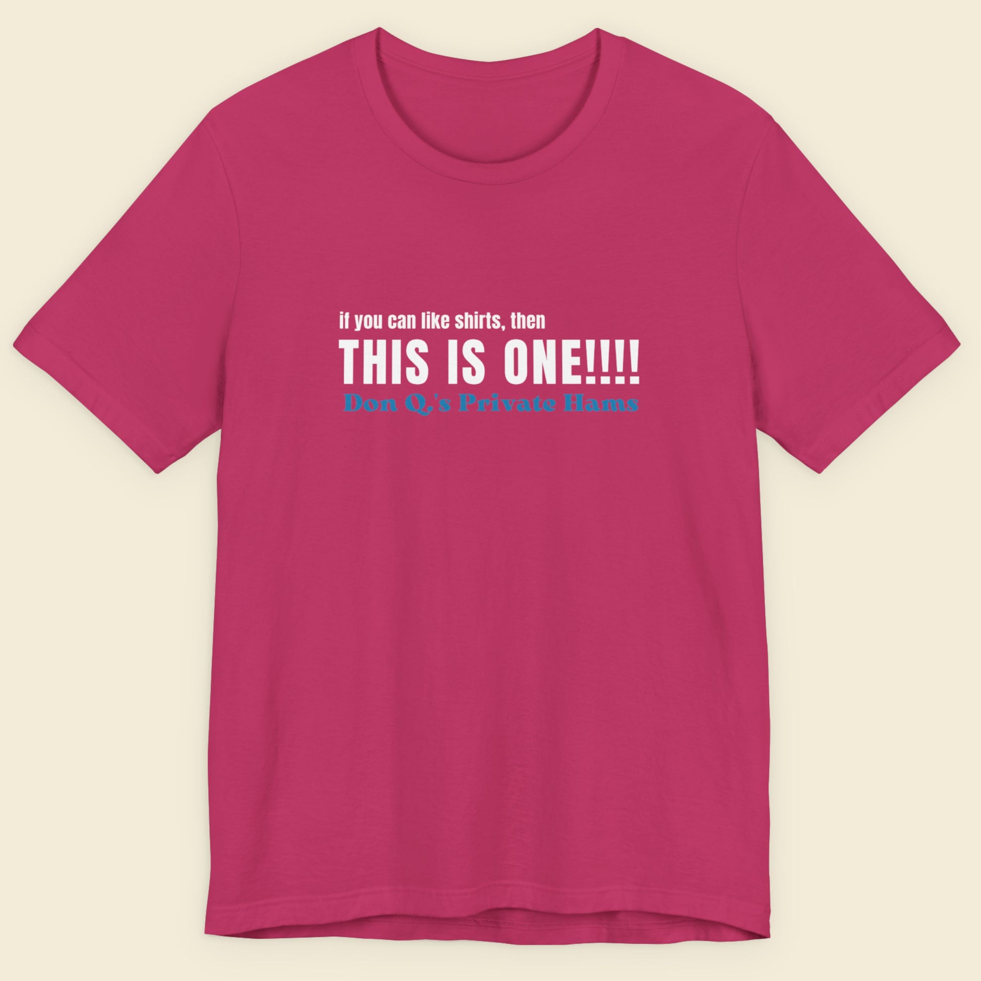 Pink t-shirt with humorous colorful text on a beige background.