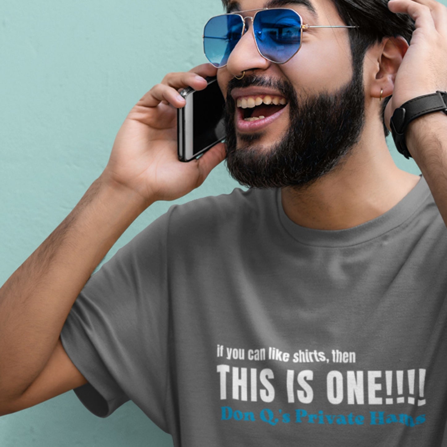 Man wearing a grey t-shirt with humorous colorful text on a blue background.
