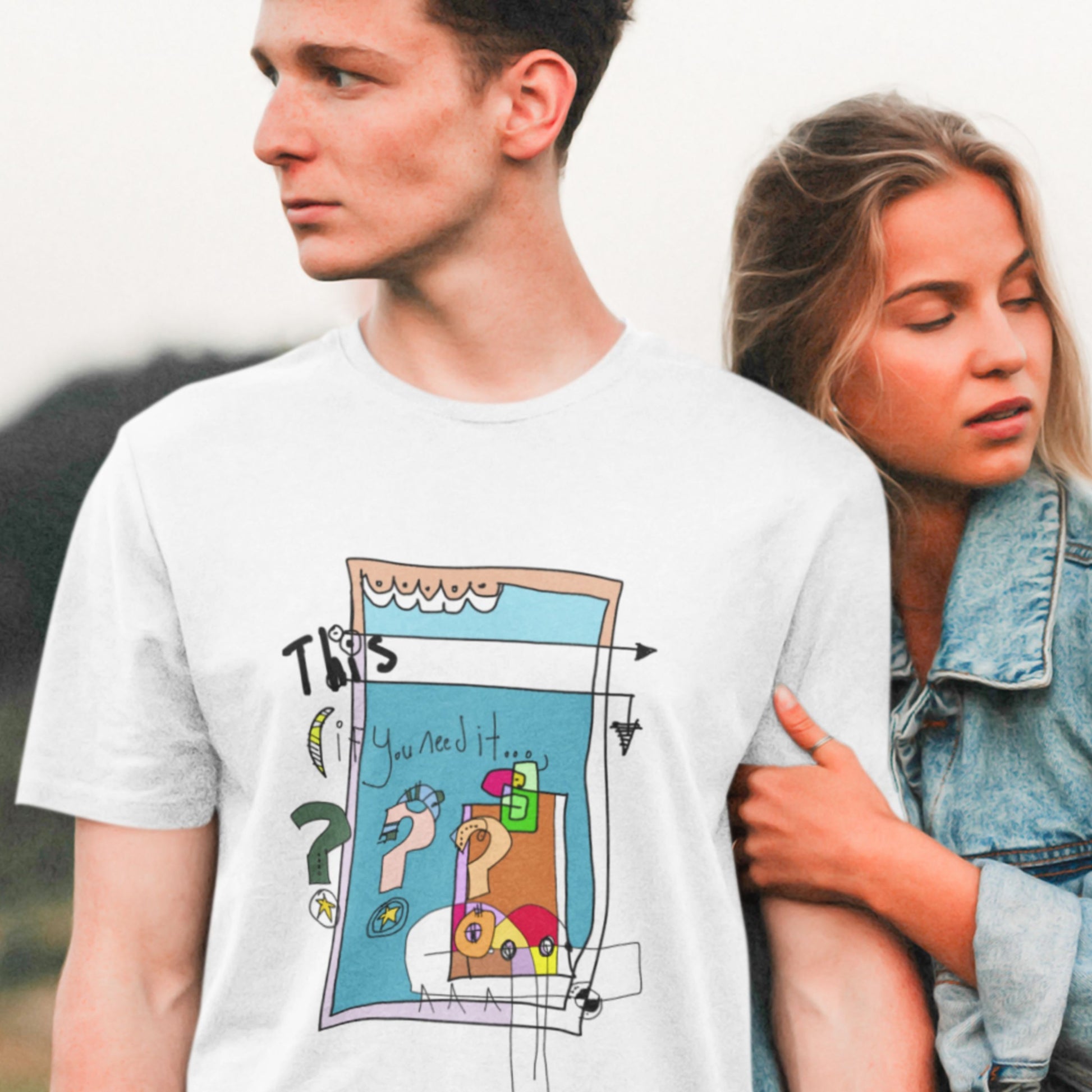Man wearing a white t-shirt with a colorful abstract drawing outdoors with his girlfriend.