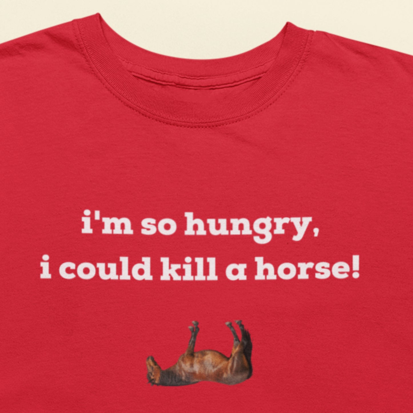 Red t-shirt with white text and horse graphic on a beige background