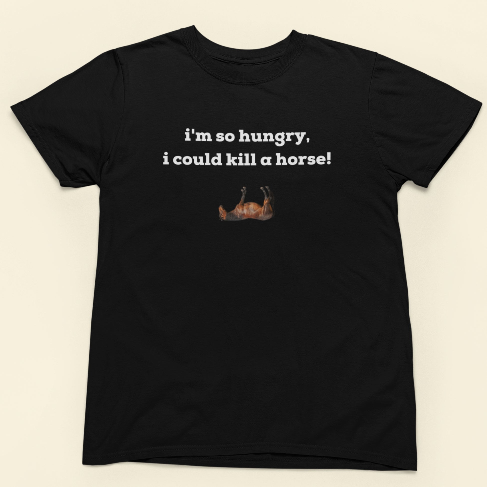 Black t-shirt with humorous text and graphic on a beige background