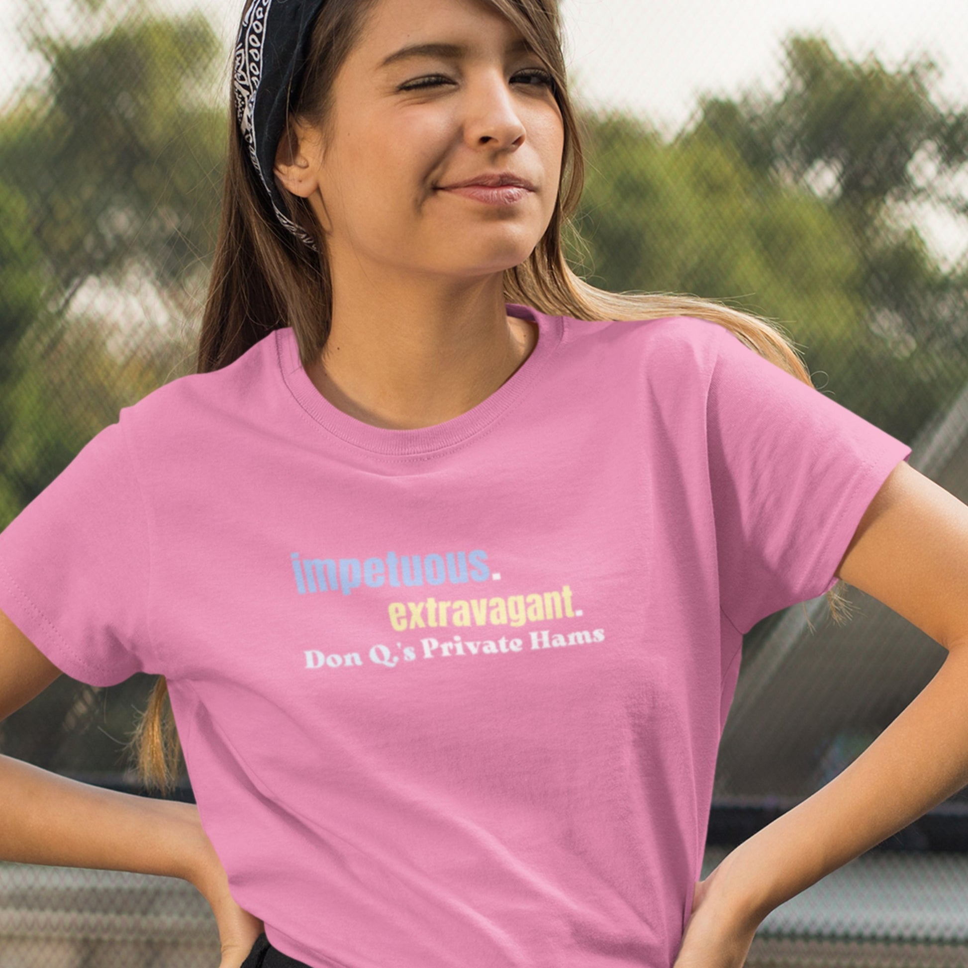 Person wearing a pink t-shirt with text outdoors.