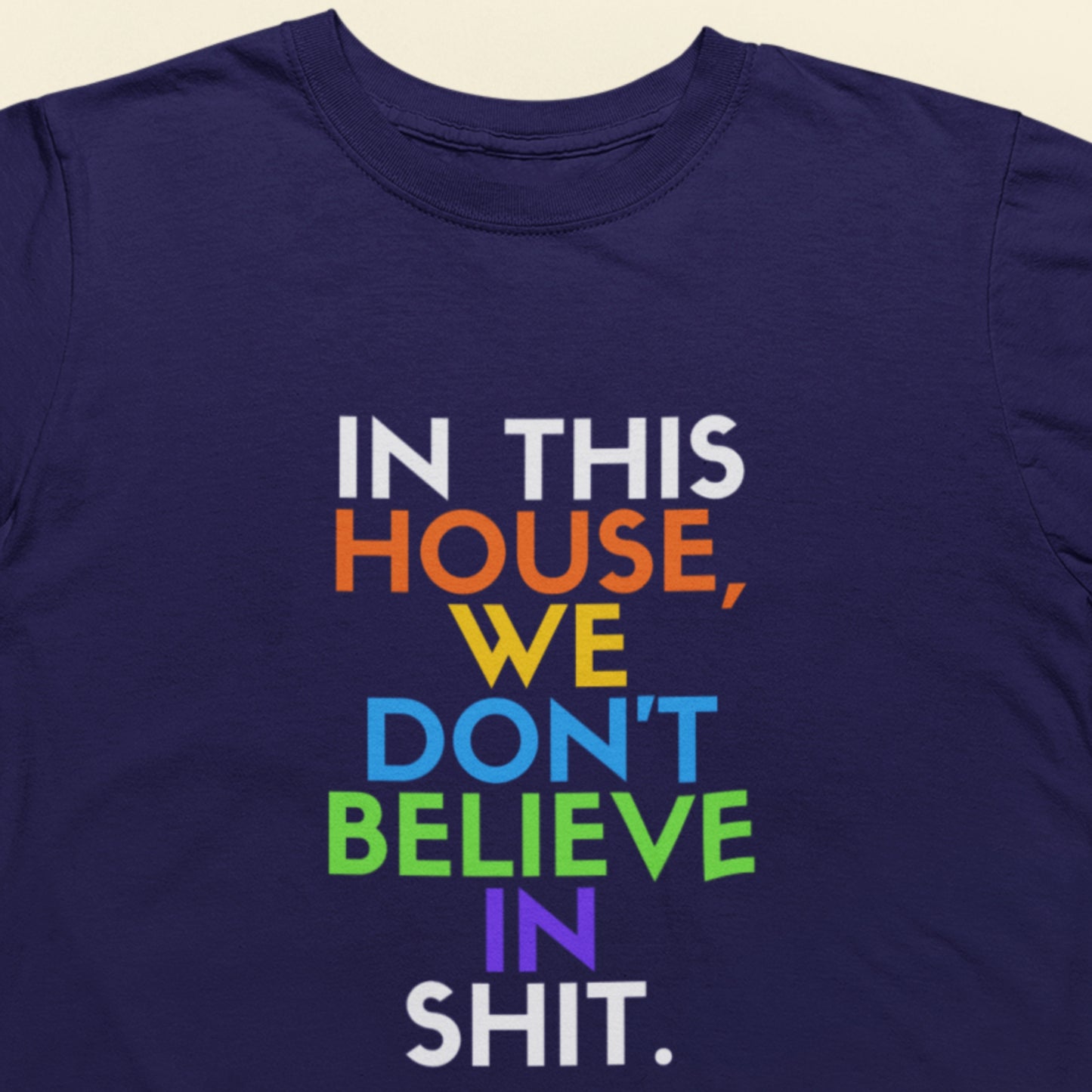 Navy blue t-shirt with colorful text on a beige background