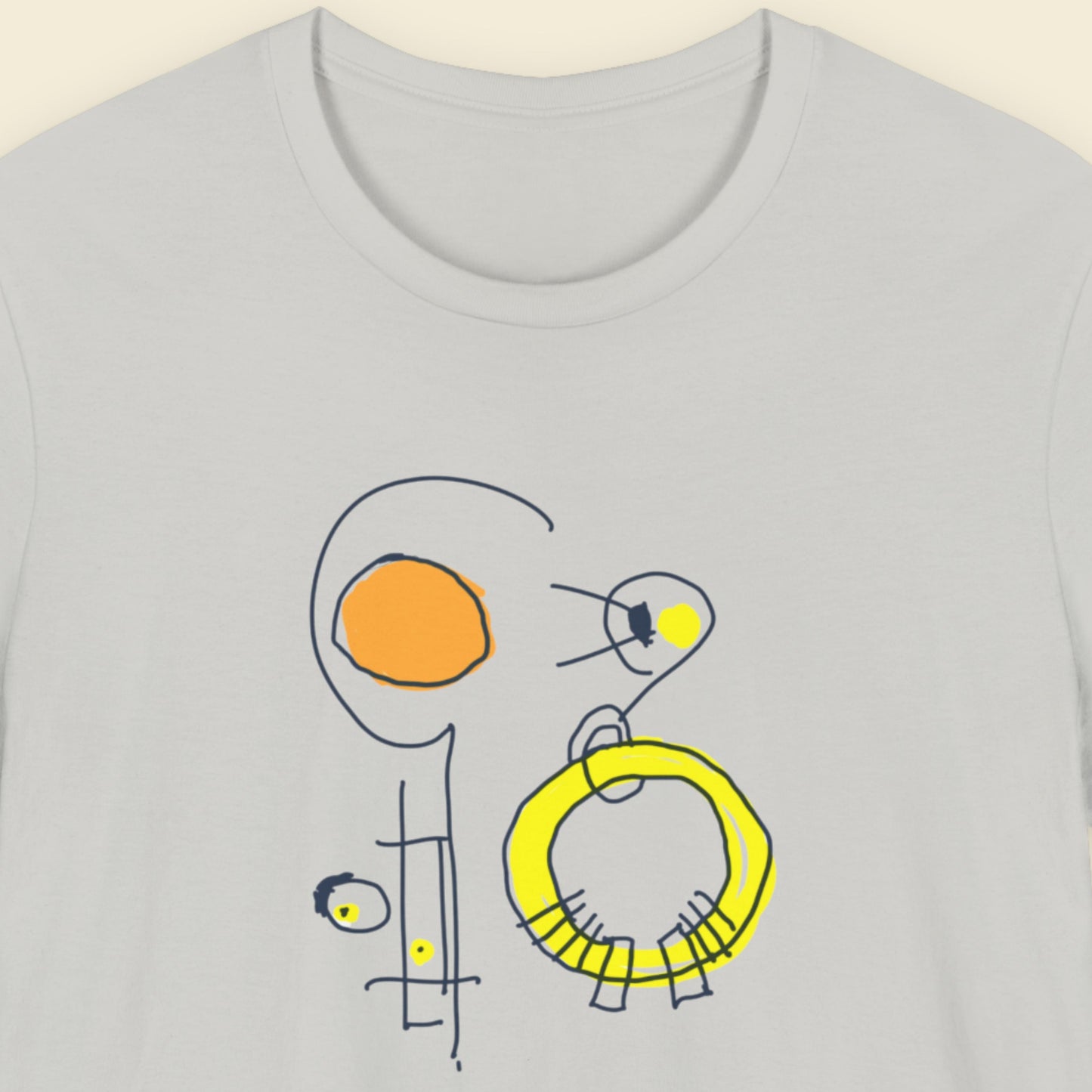 Grey t-shirt with a colorful abstract drawing on a beige background.