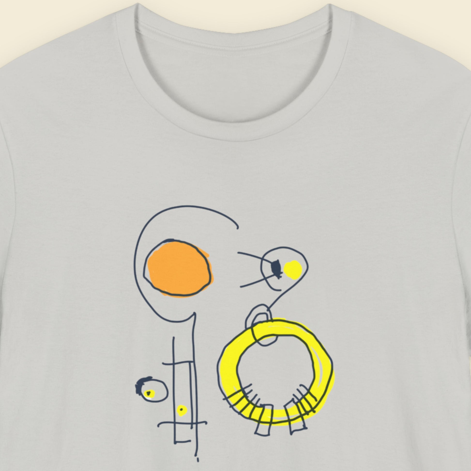 Grey t-shirt with a colorful abstract drawing on a beige background.