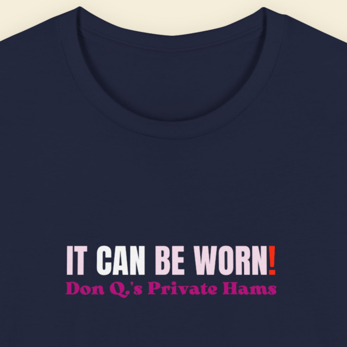 Navy blue t-shirt with humorous text design on a beige background.