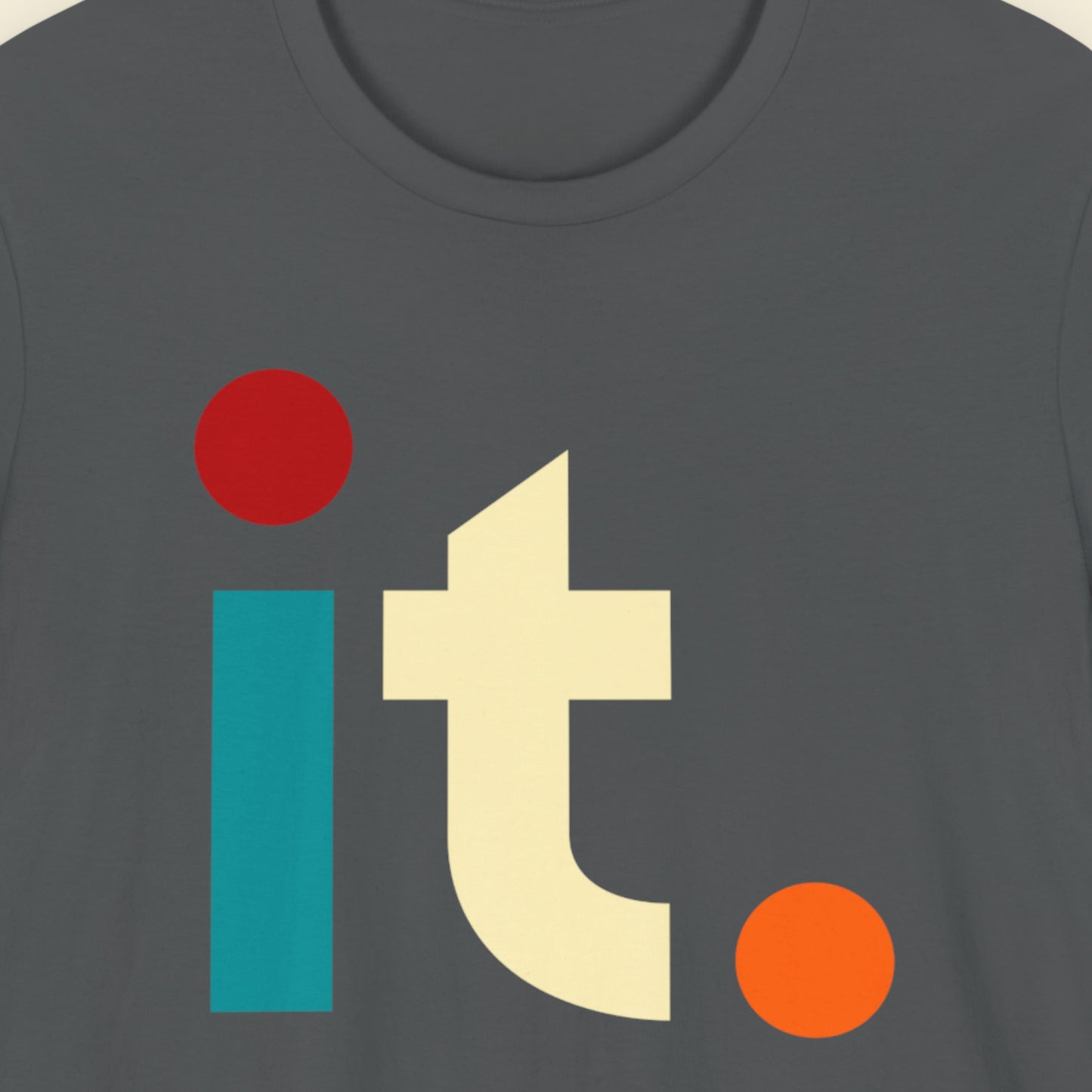 Grey t-shirt with colorful geometric 'it.' text on a beige background.