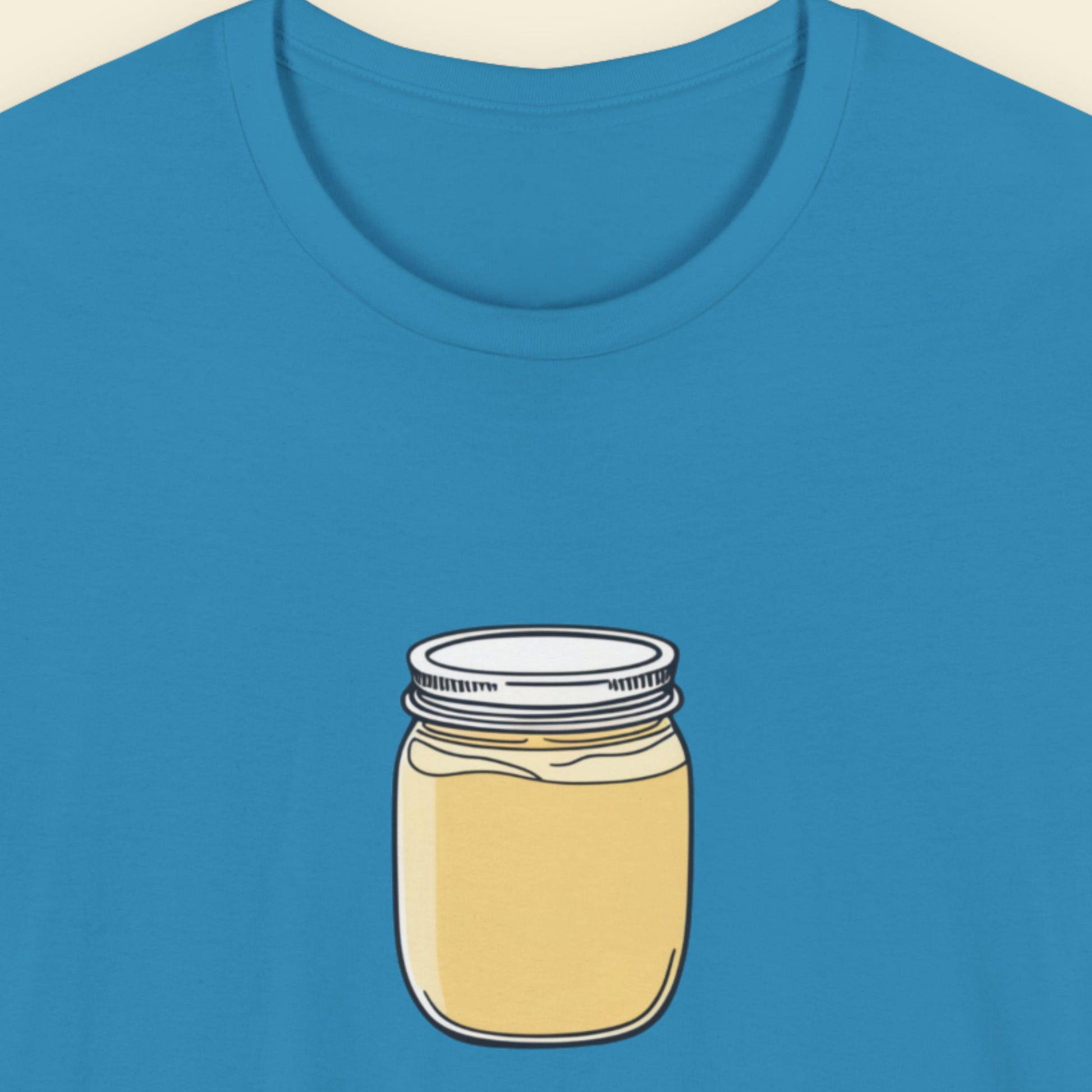 Blue shirt with a drawing of a jar of custard.