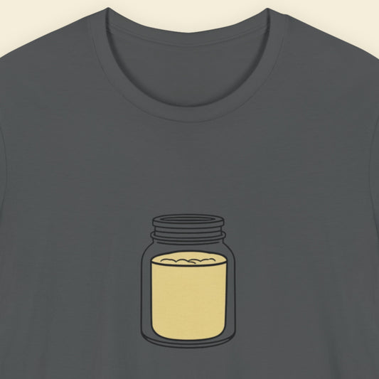 Grey t-shirt with a drawing of a jar of mustard powder on a beige background.