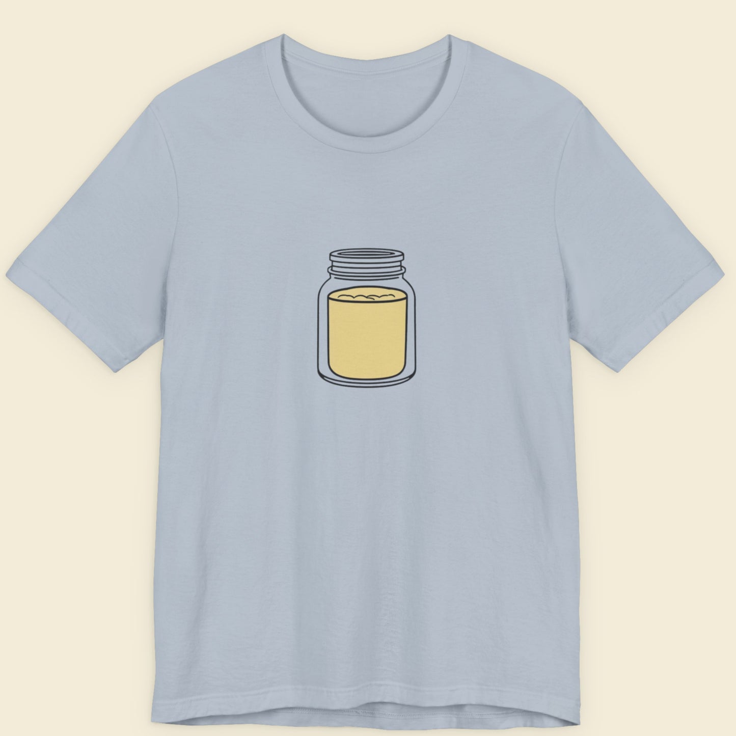 Light blue t-shirt with a drawing of a jar of mustard powder on a beige background.