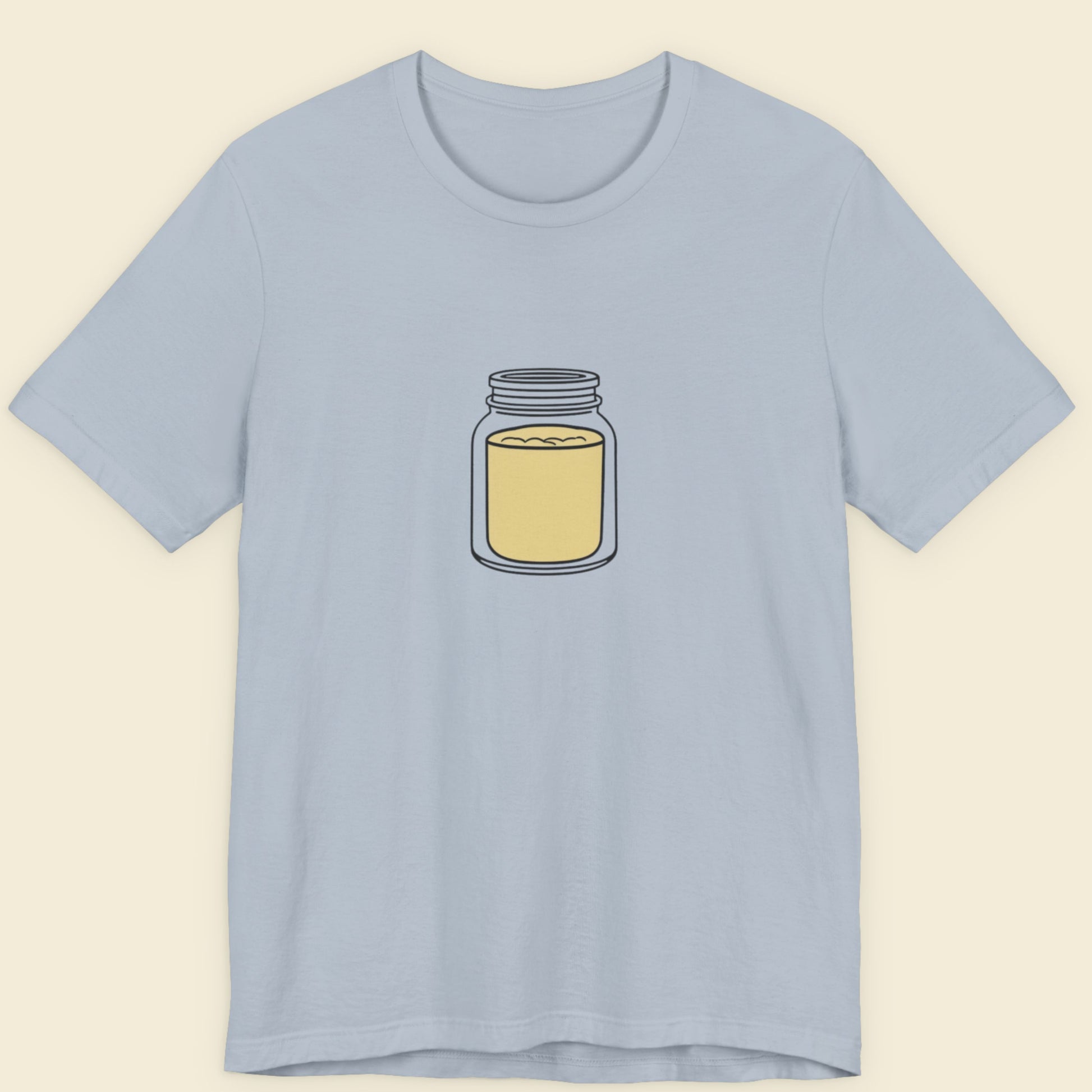 Light blue t-shirt with a drawing of a jar of mustard powder on a beige background.