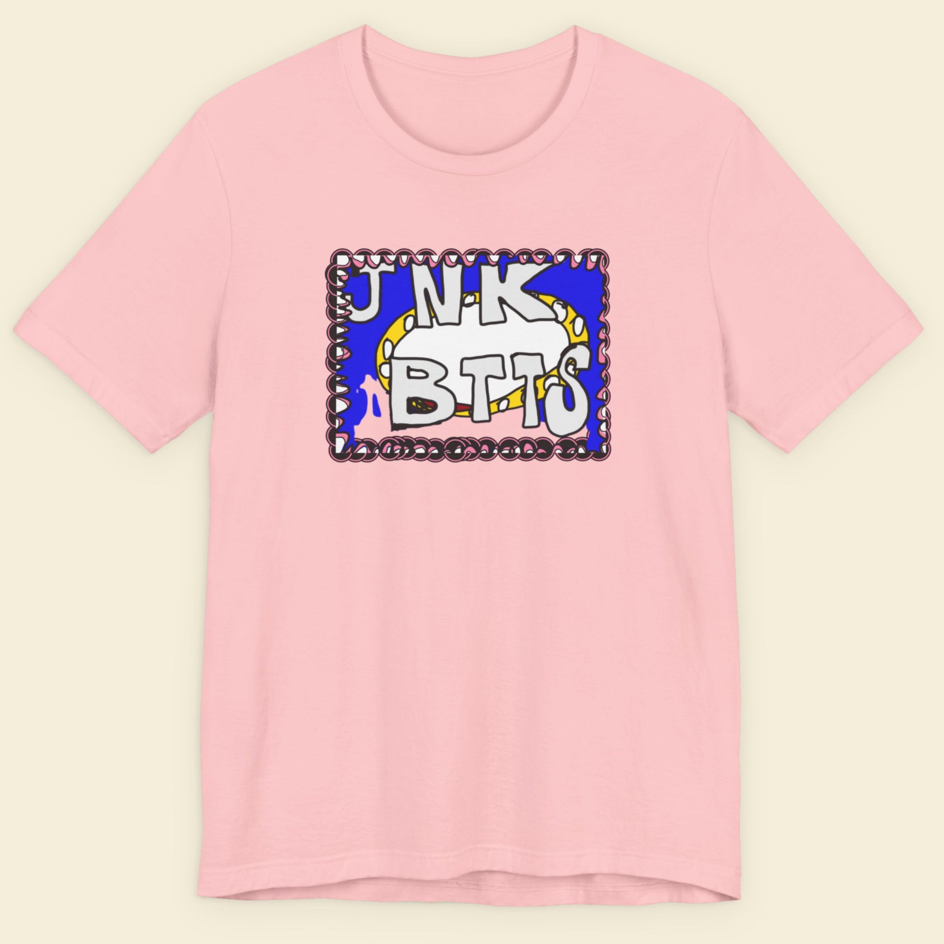 Pink t-shirt with colorful graphic design on a beige background.