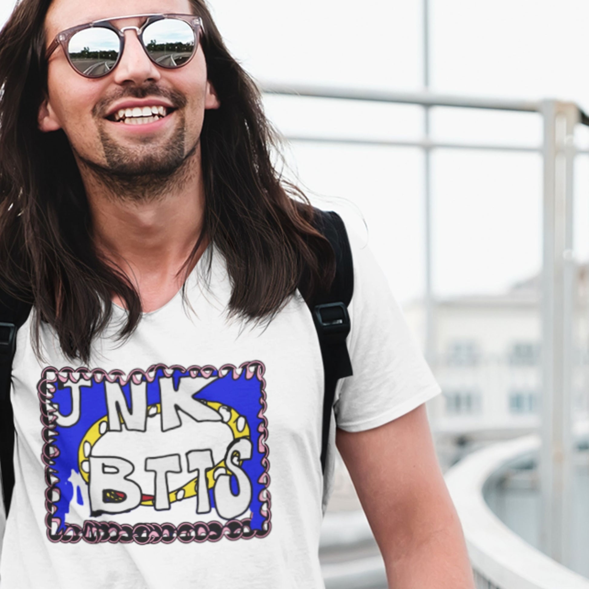 Man wearing sunglasses and a white t-shirt with a colorful graphic design.