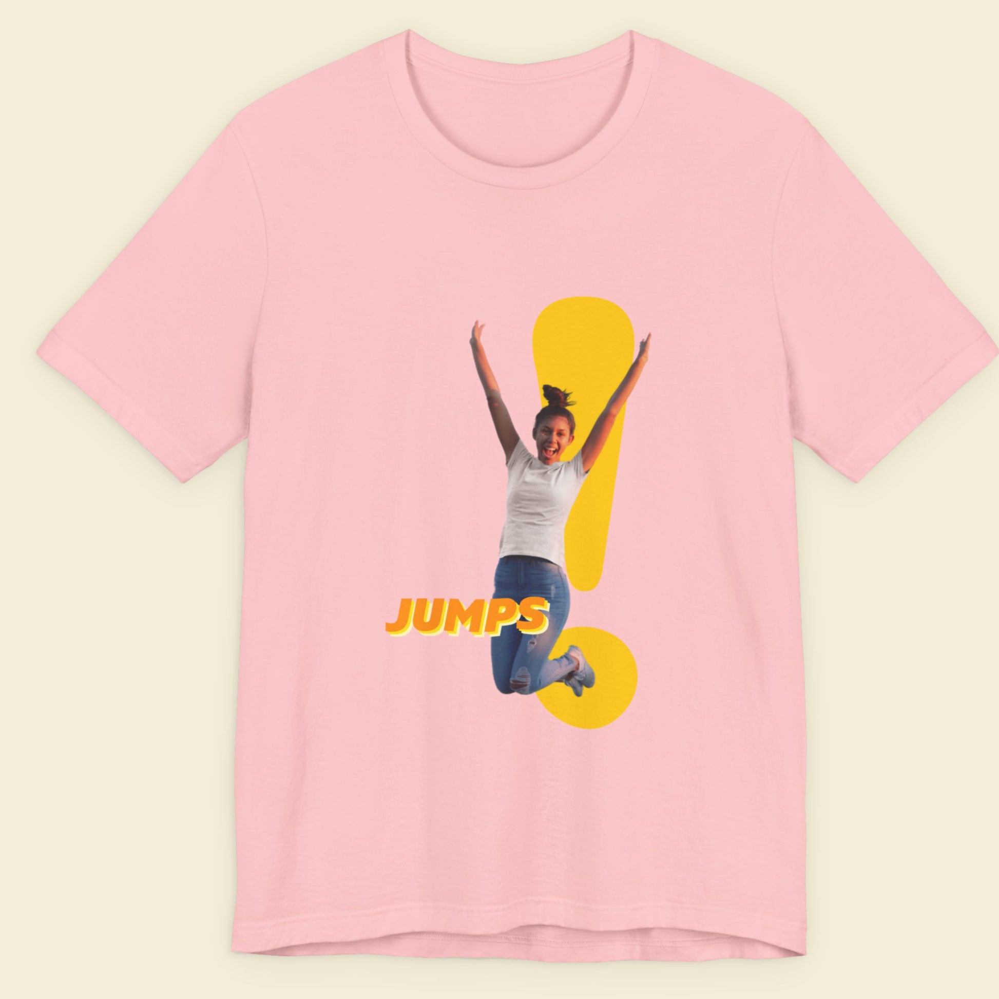 Pink t-shirt with a graphic of a person jumping and the word 'JUMPS' on a beige background.