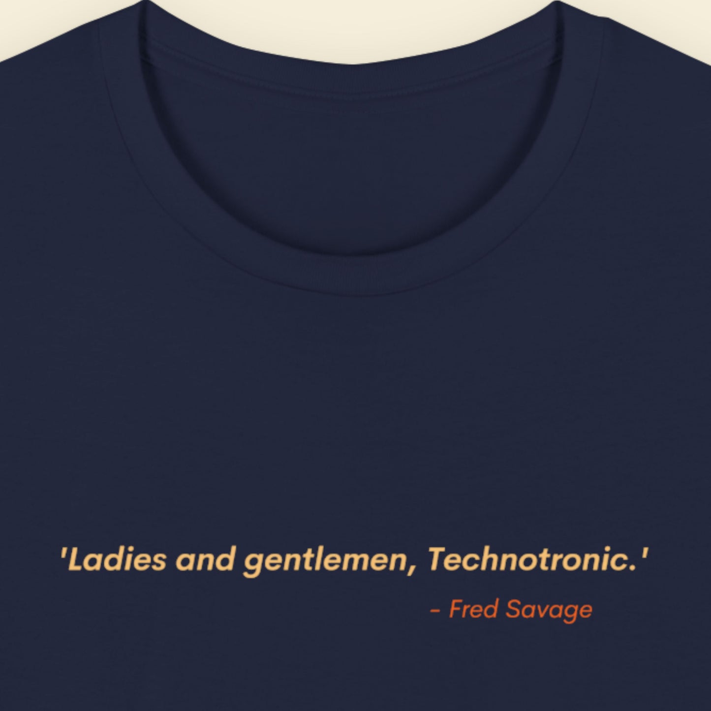 Navy blue t-shirt with humorous colorful text on a beige background.