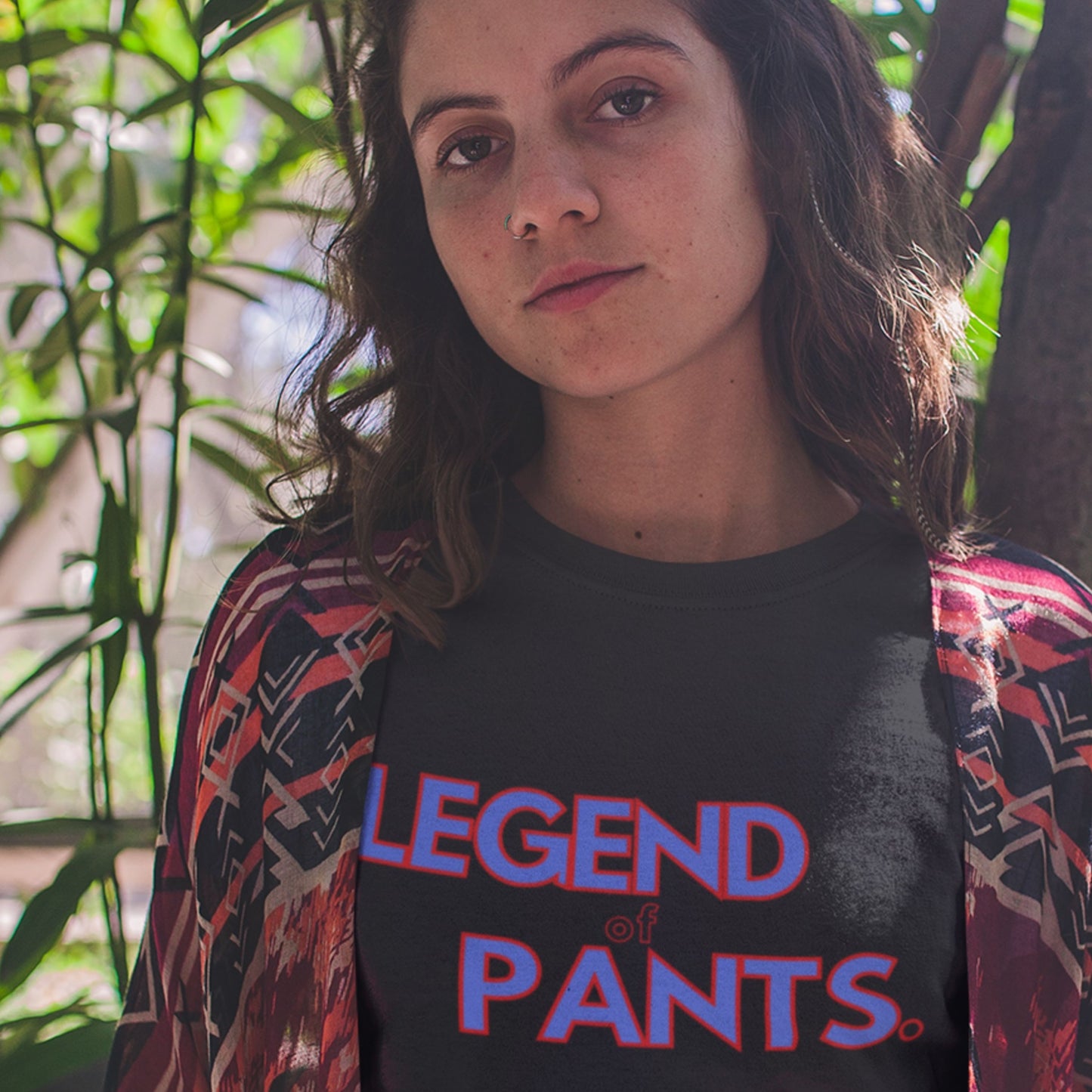 Person wearing a black t-shirt with 'LEGEND of PANTS' text, standing outdoors with greenery in the background.