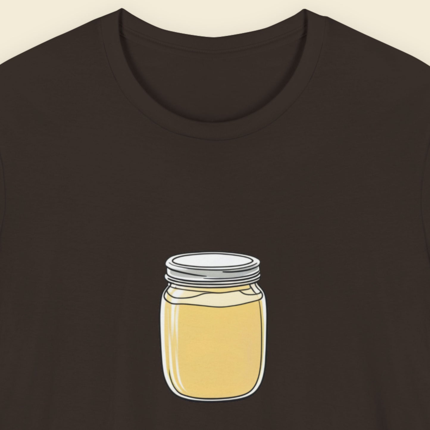 Brown t-shirt with a fun, colorful cartoon illustration on a beige background.