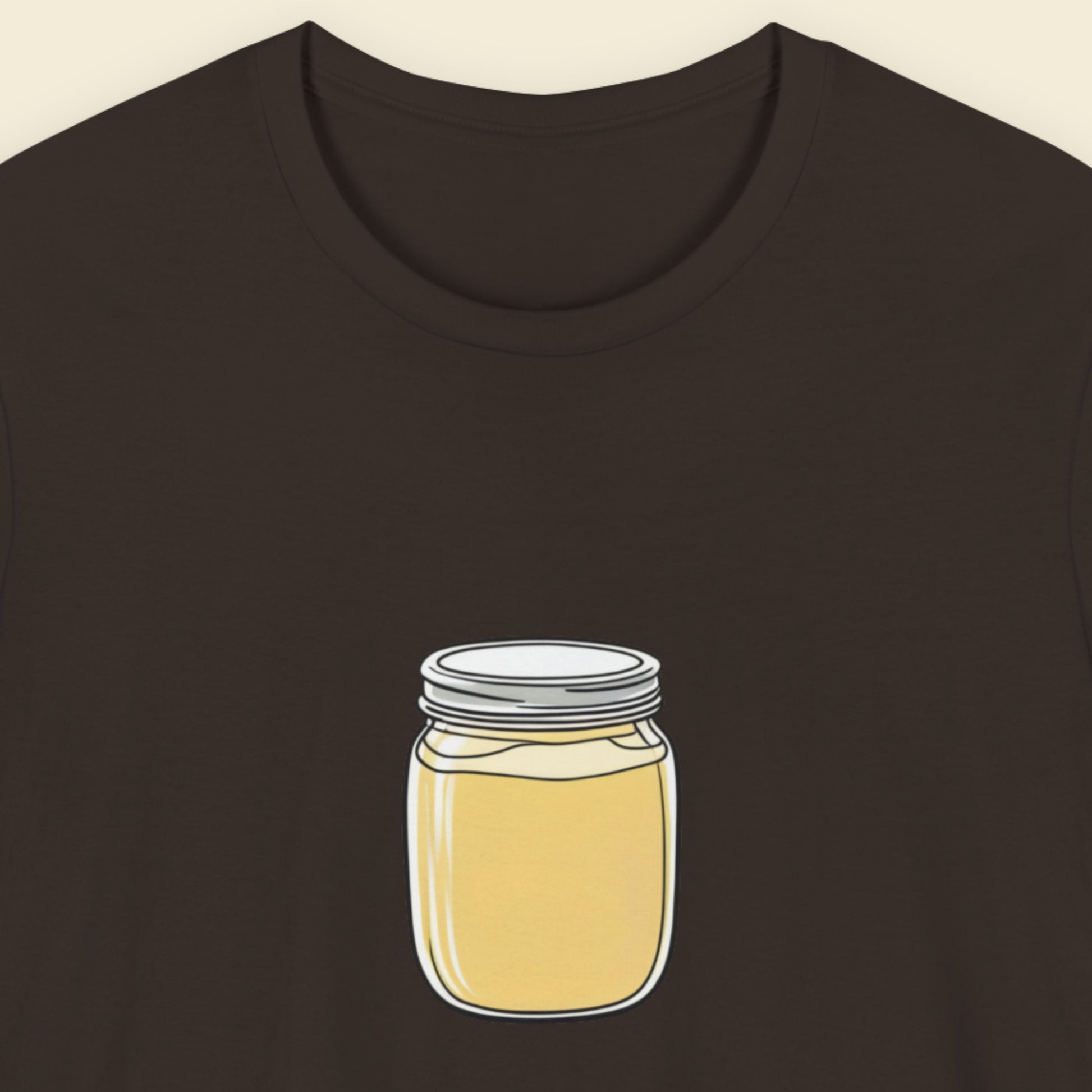 Brown t-shirt with a fun, colorful cartoon illustration on a beige background.