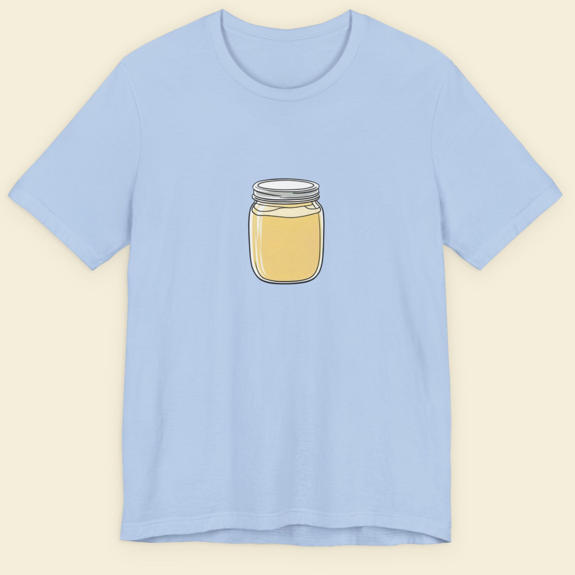 Light blue t-shirt with a fun, colorful cartoon illustration on a beige background.