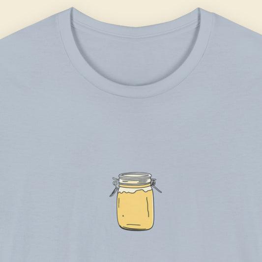 Light blue t-shirt with a drawing of a little snap top yellow jar.
