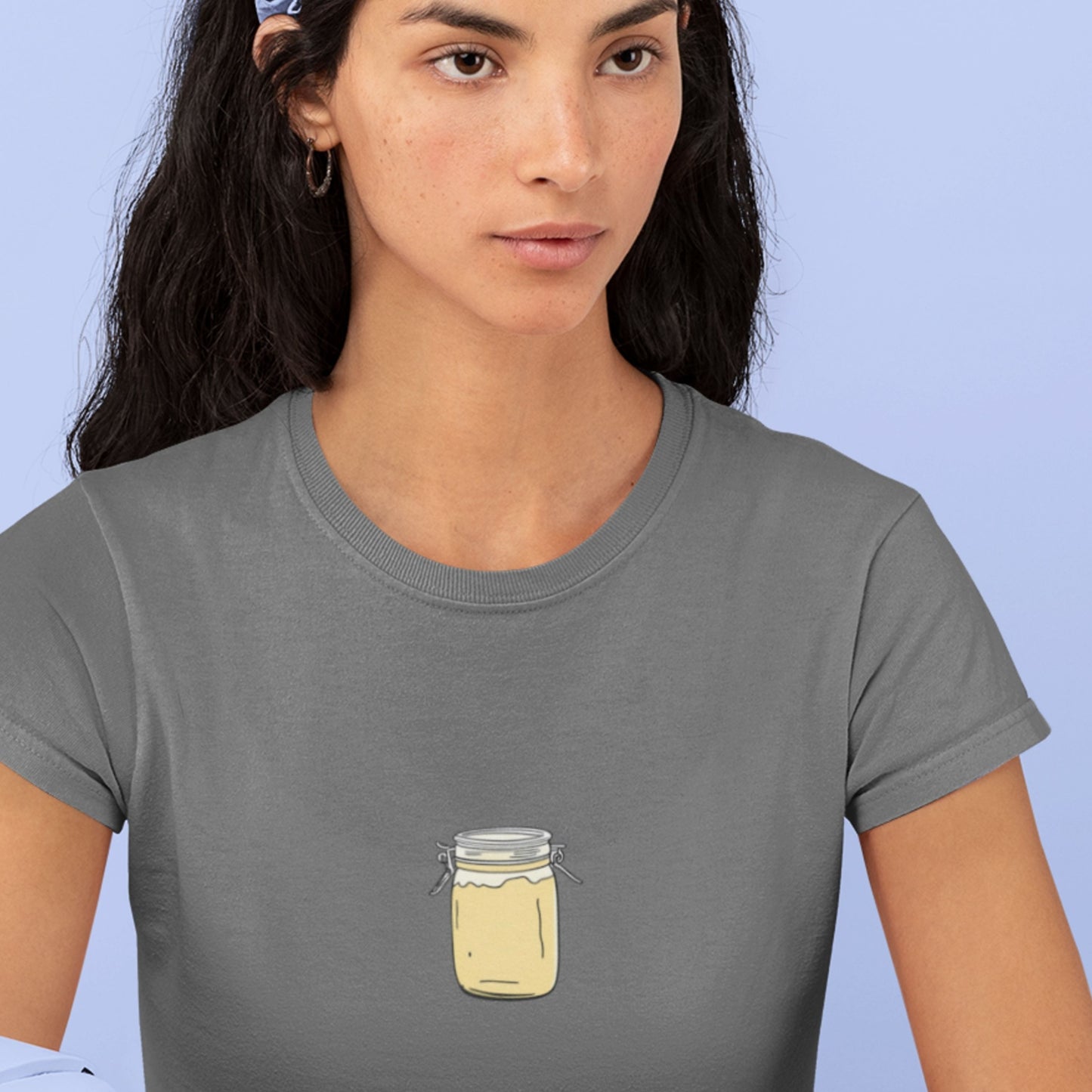 Woman wearing a gray t-shirt with a mason jar design on a light blue background