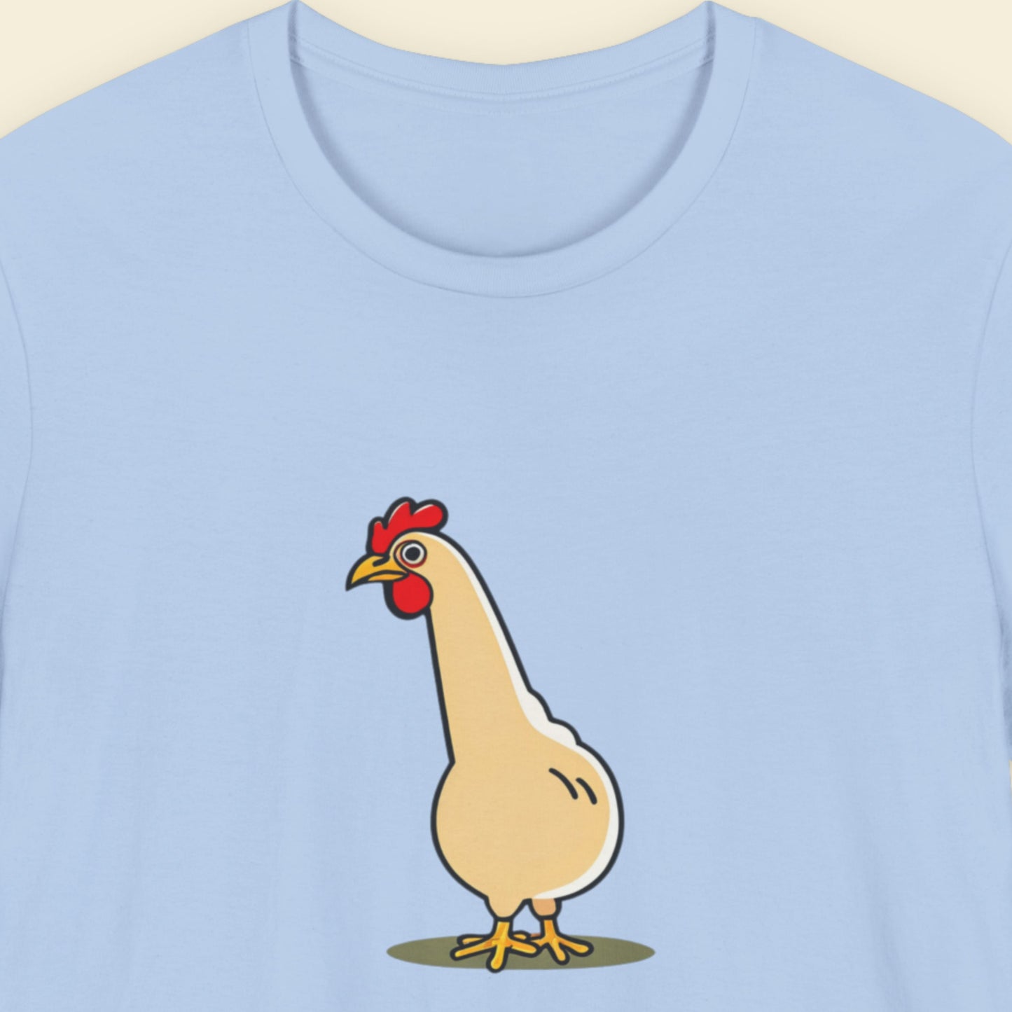 Light blue t-shirt with a cartoon chicken design on a beige background
