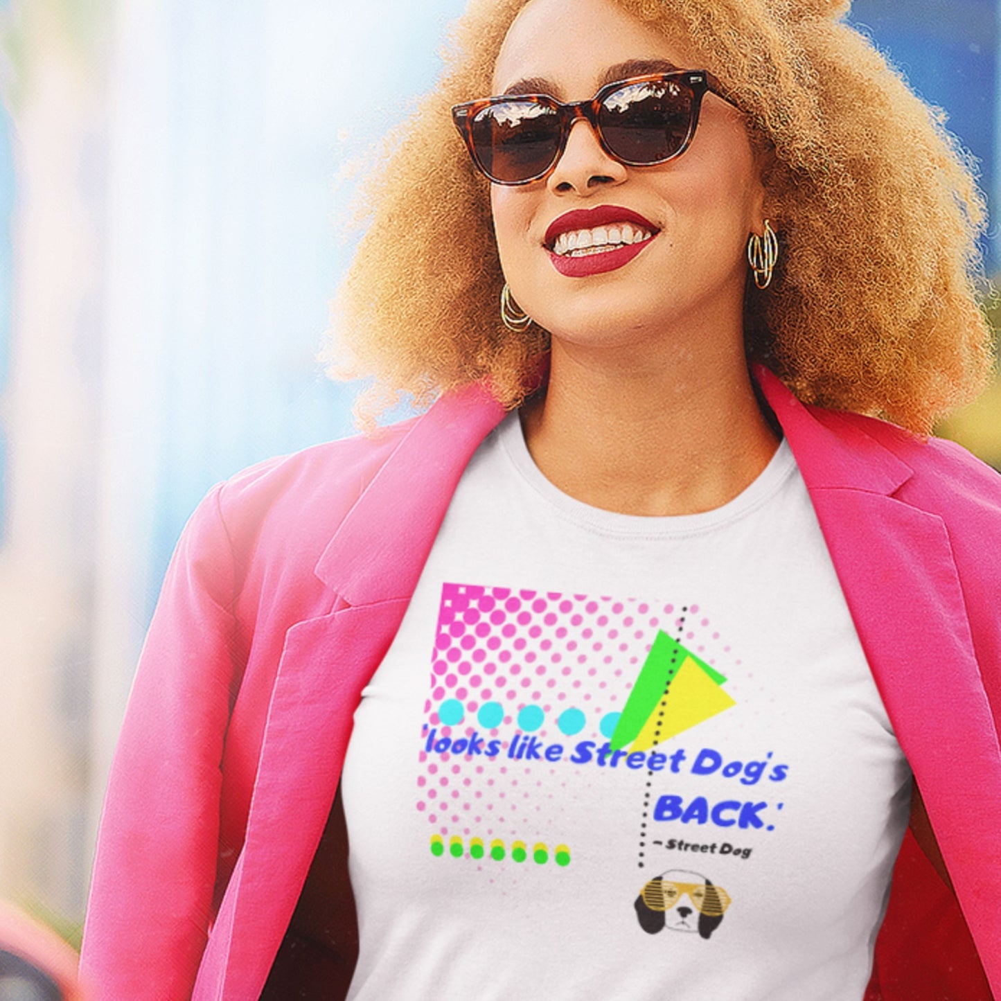 Woman wearing a white t-shirt with colorful graphics and text, standing outdoors.