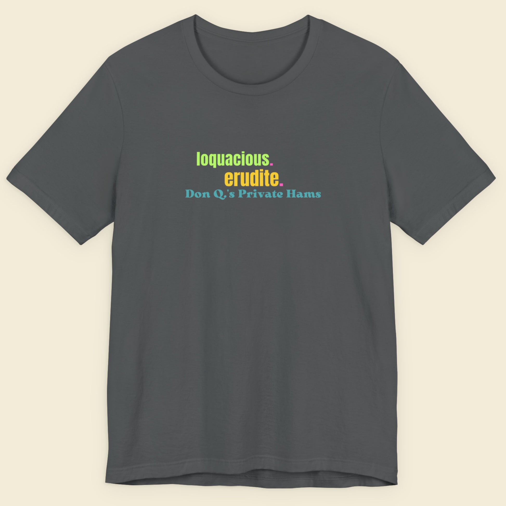 Gray t-shirt with colorful text on a beige background.