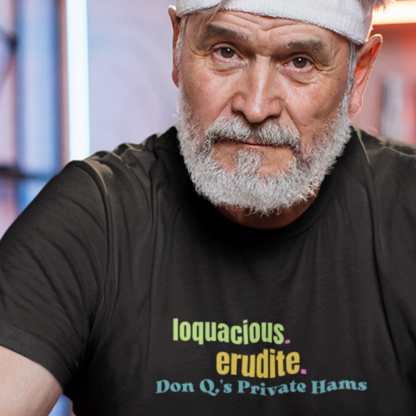 Man wearing a black t-shirt with colorful text in a studio setting.