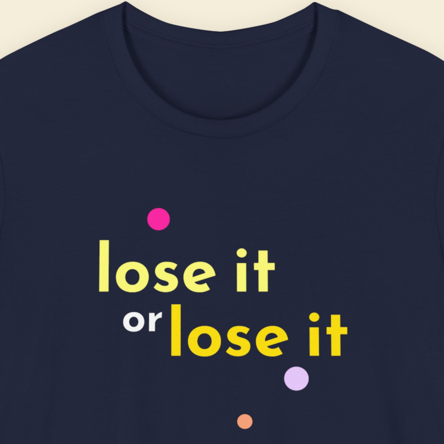 Navy blue t-shirt with 'lose it or lose it' text in yellow and pink dots on a beige background.