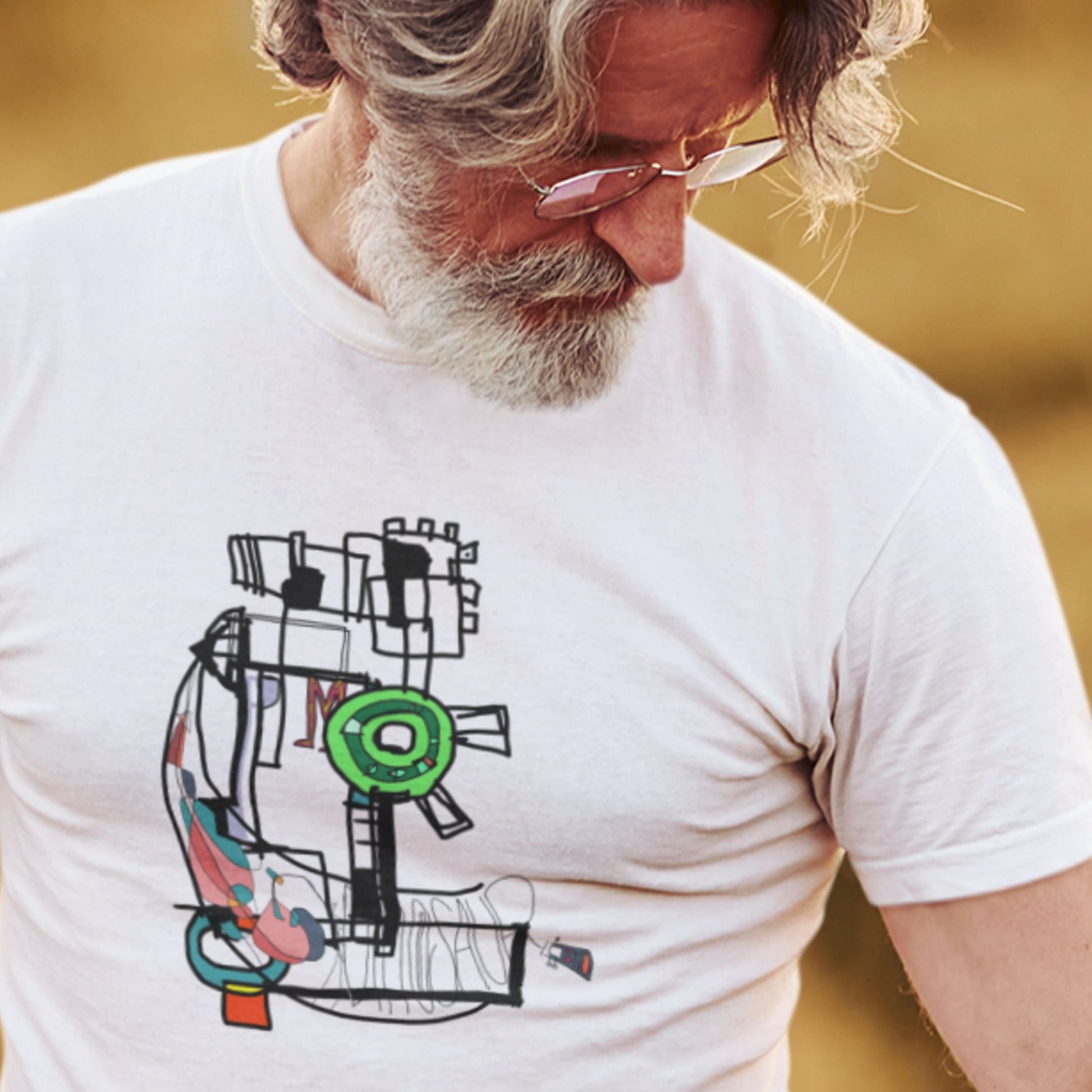 Man wearing a white t-shirt with a colorful abstract design.