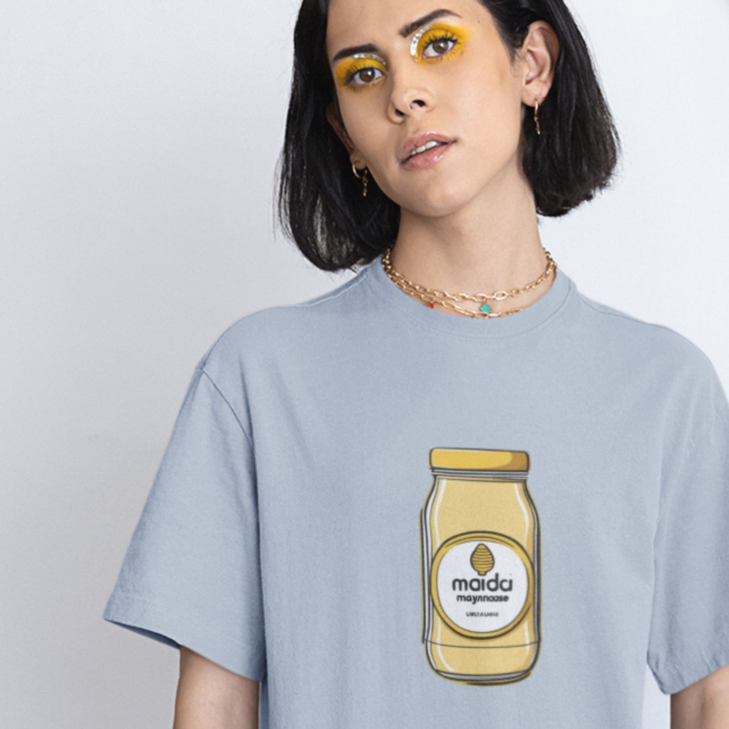 Woman wearing a light blue t-shirt with a drawing of a name brand condiment jar.