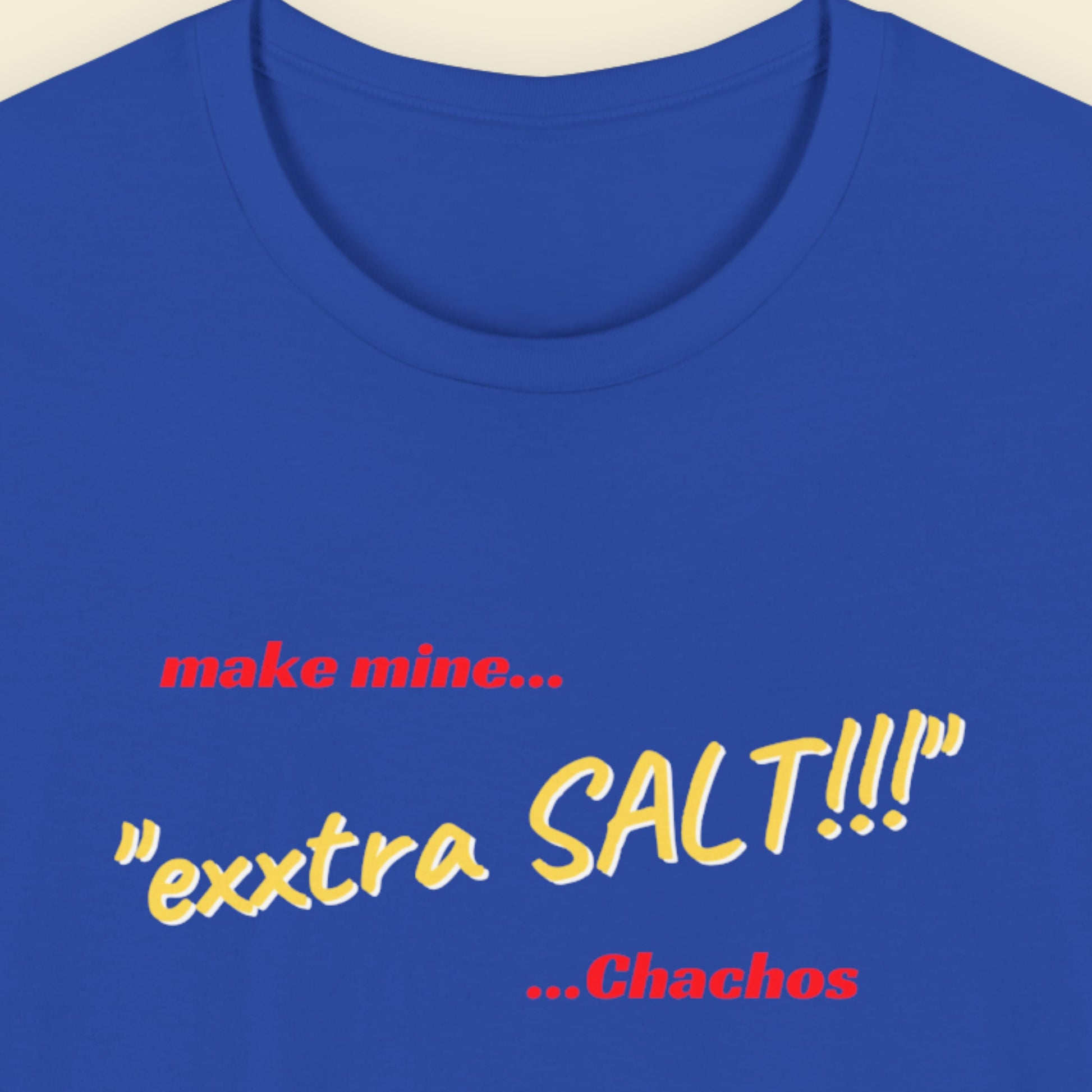 Blue t-shirt with text 'make mine... “extra SALT!!!” ...Chachos' on a beige background.
