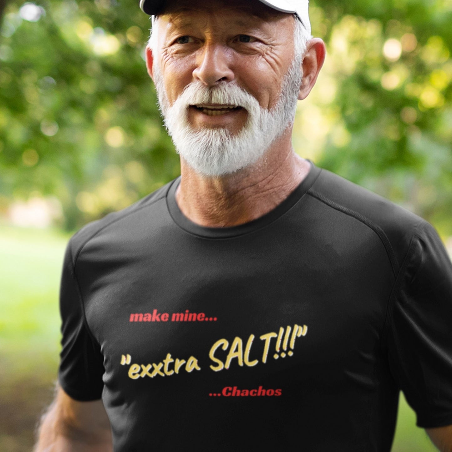 Man wearing a black t-shirt with humorous text in an outdoor setting.