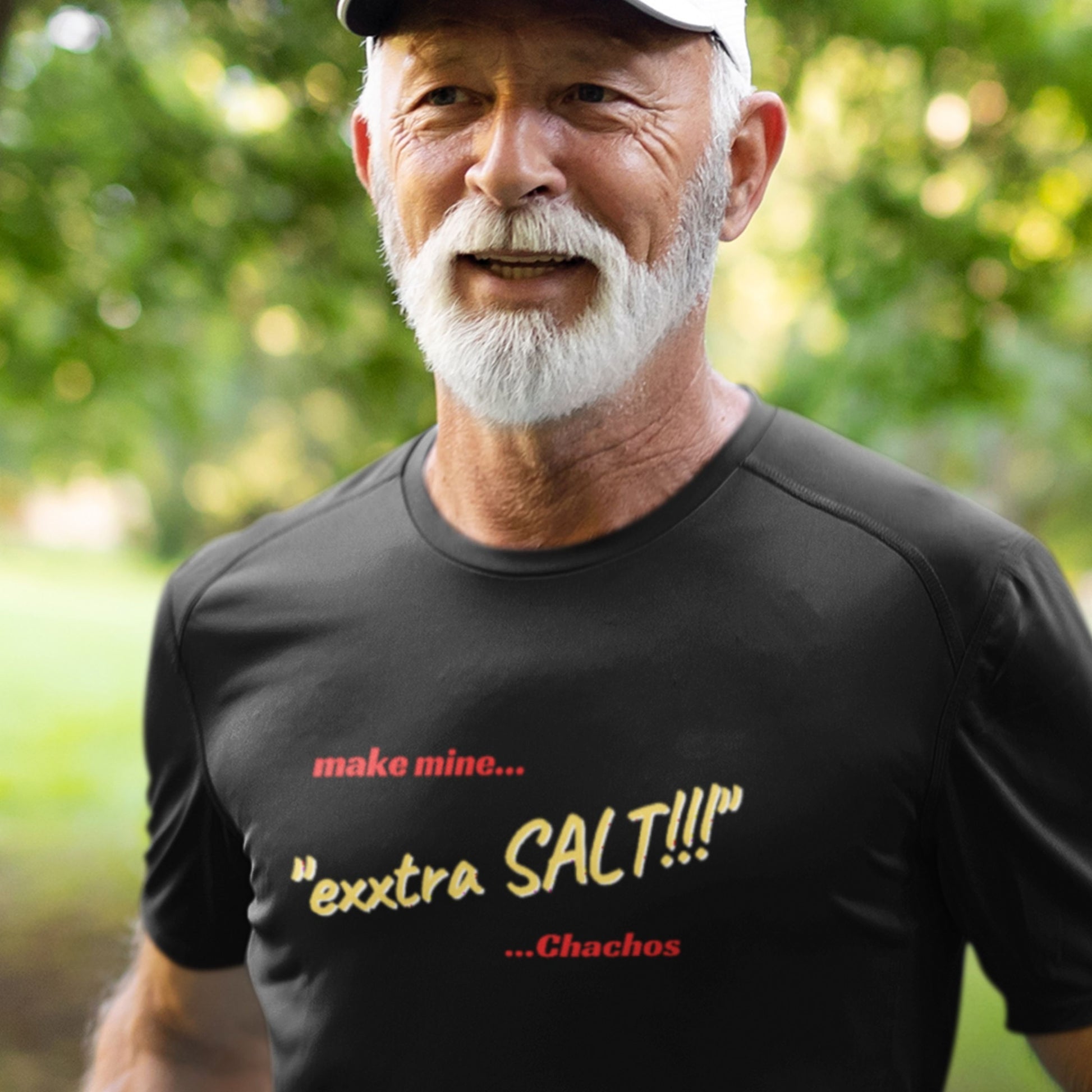 Man wearing a black t-shirt with humorous text in an outdoor setting.