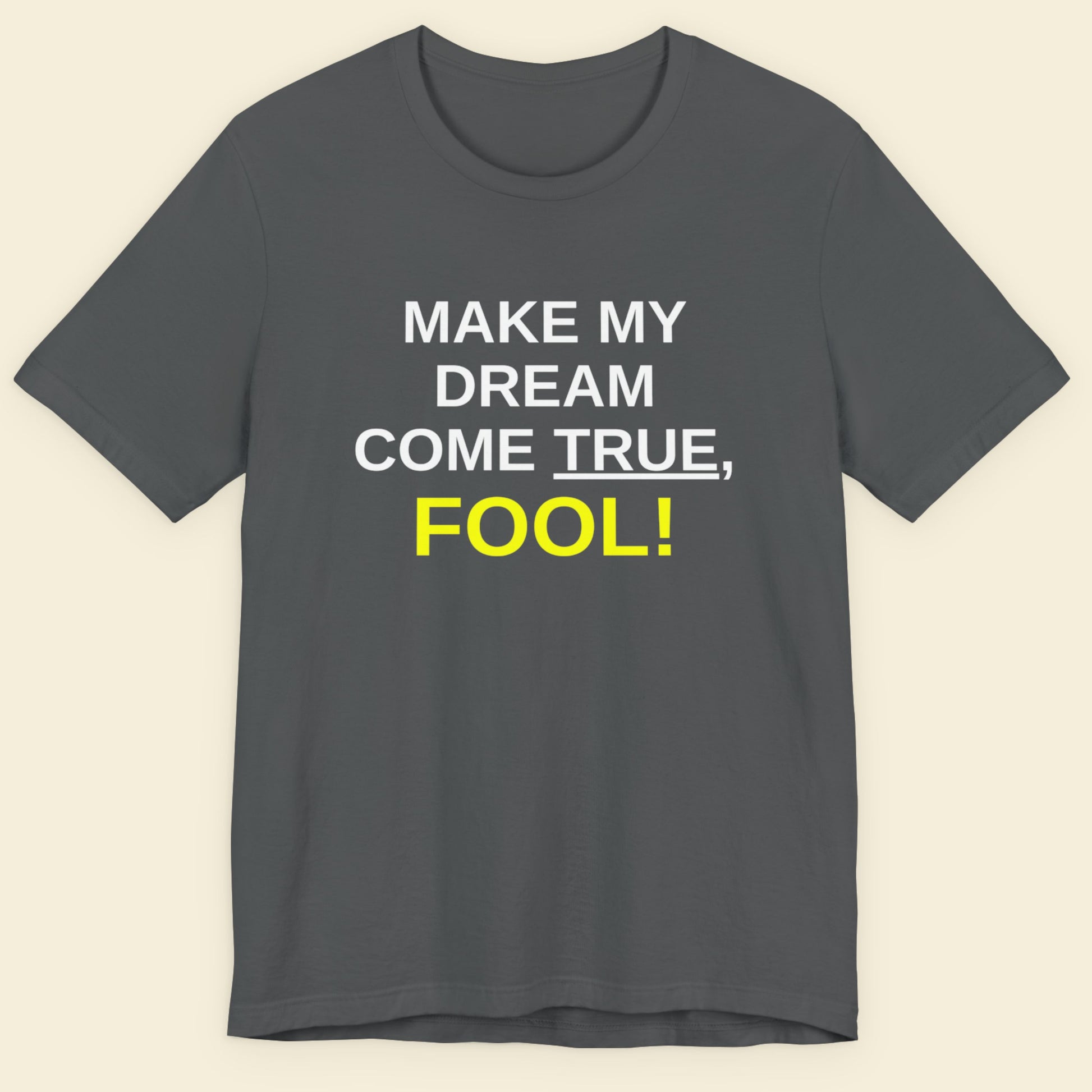 Gray t-shirt with motivational text 'MAKE MY DREAM COME TRUE, FOOL!' on a beige background.