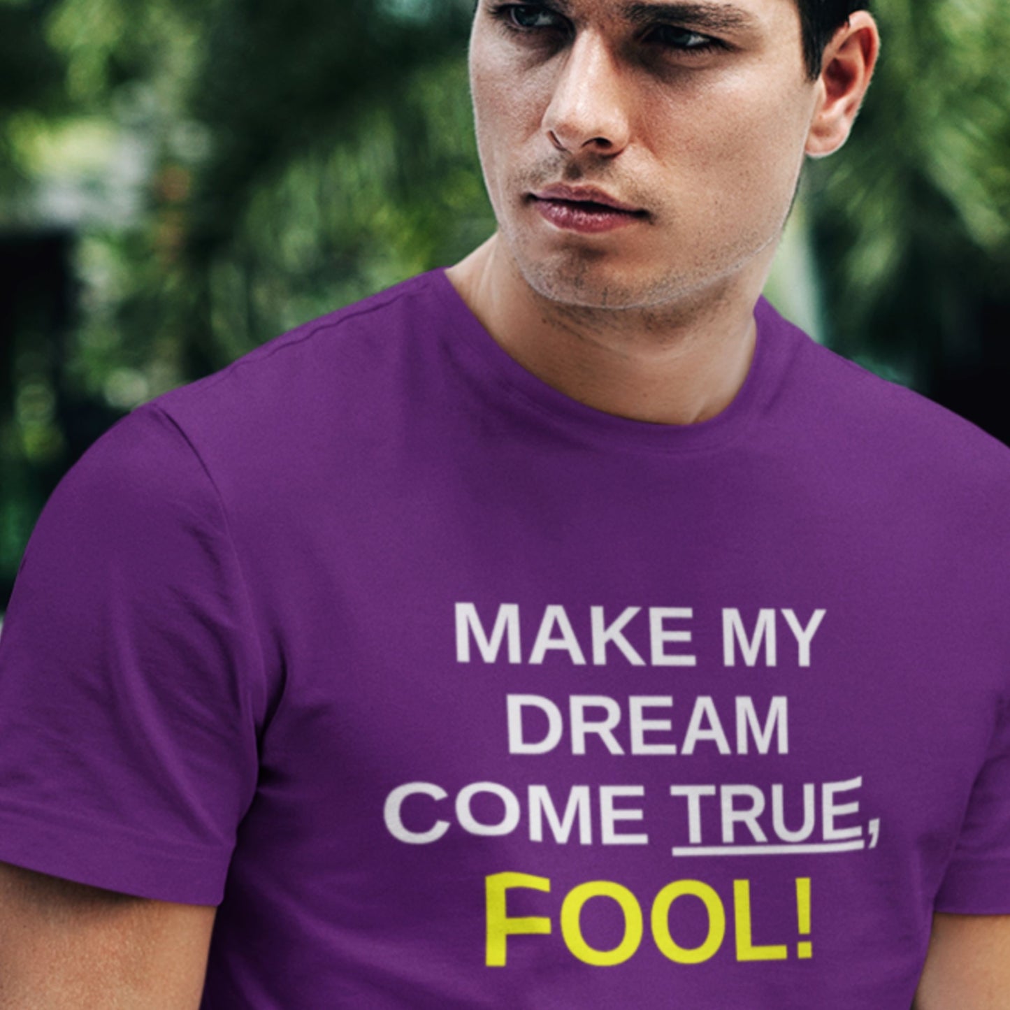 Man wearing a purple t-shirt with motivational text in an outdoor setting.