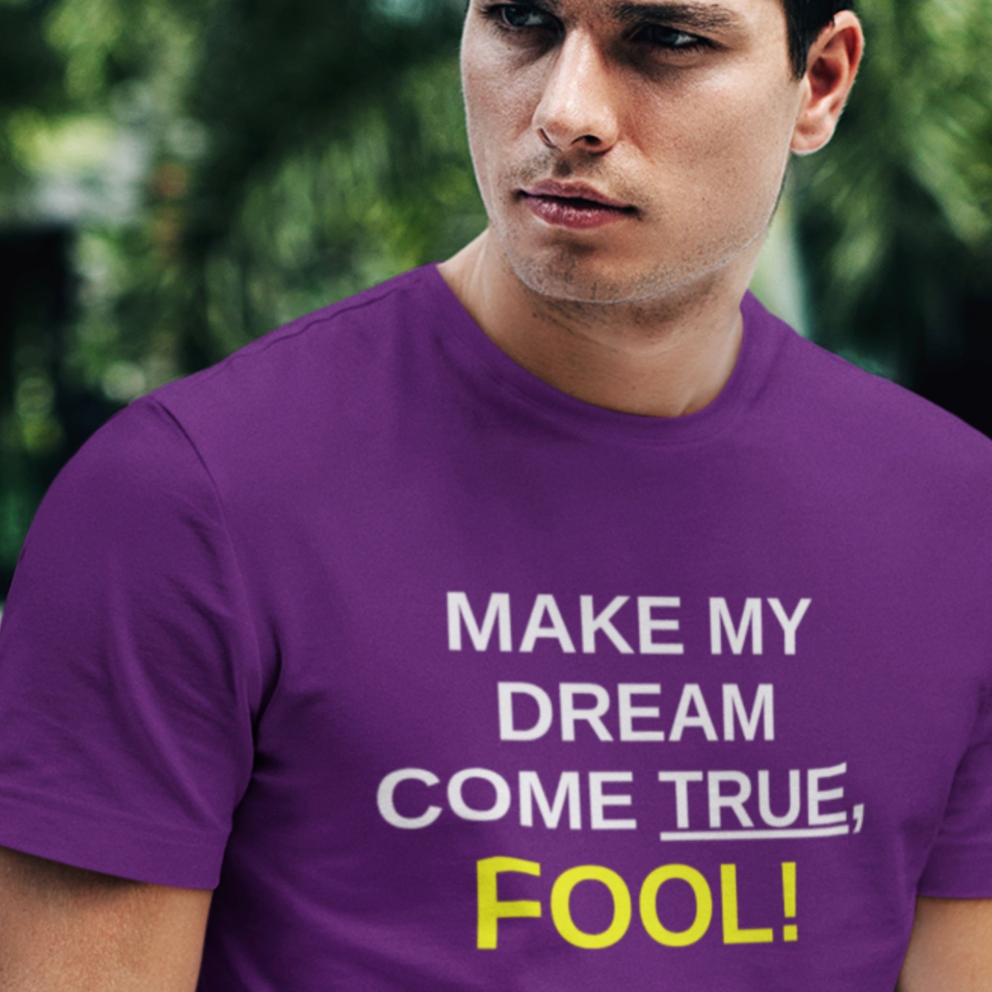 Man wearing a purple t-shirt with motivational text in an outdoor setting.