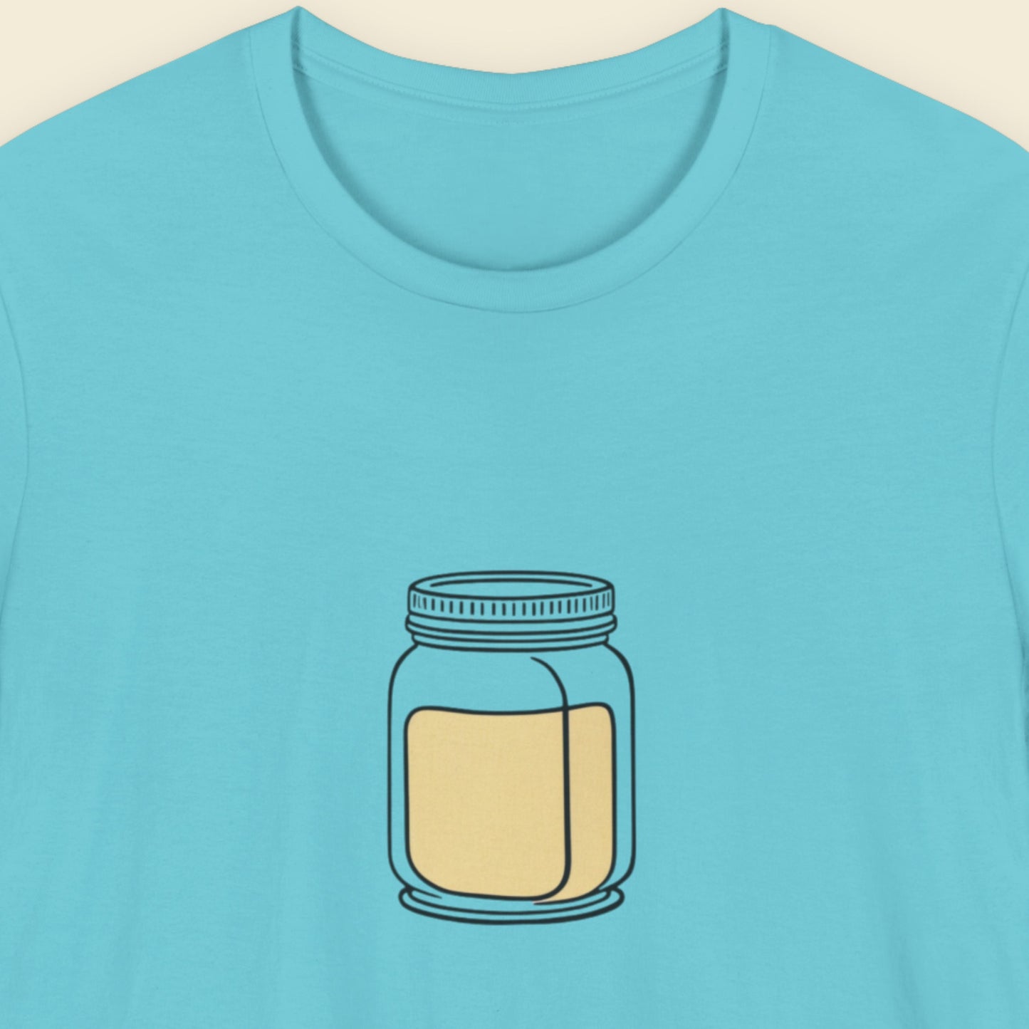 Blue t-shirt with a jar graphic on a beige background.