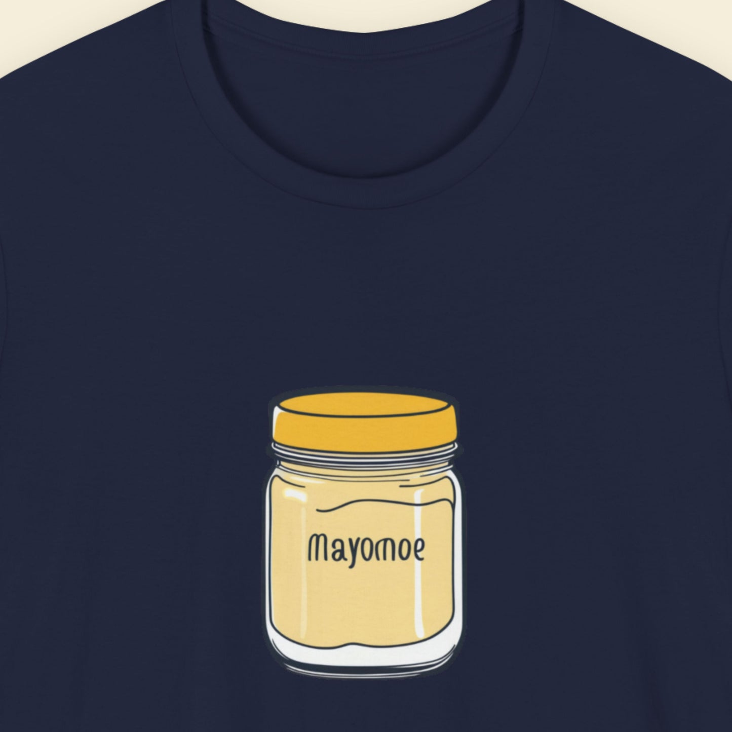 Navy t-shirt with an illustration of a jar of Mayomoe Dijon mayonnaise against a beige background.