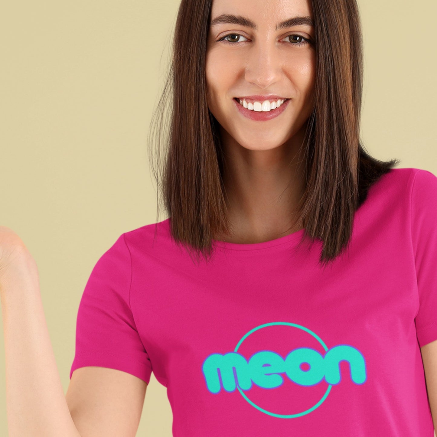 Woman wearing a pink t-shirt with 'meon' logo on a beige background.