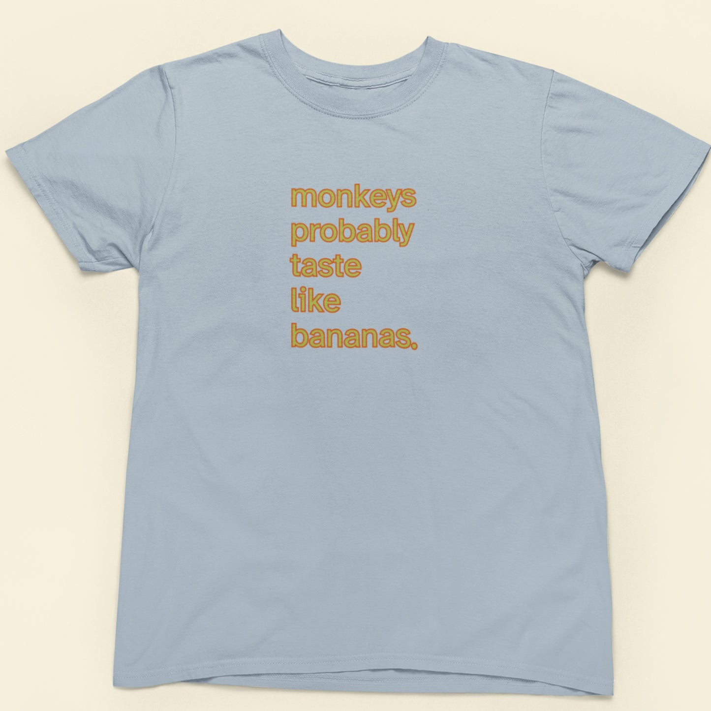 Light blue t-shirt with orange and yellow 'monkeys probably taste like bananas' text.