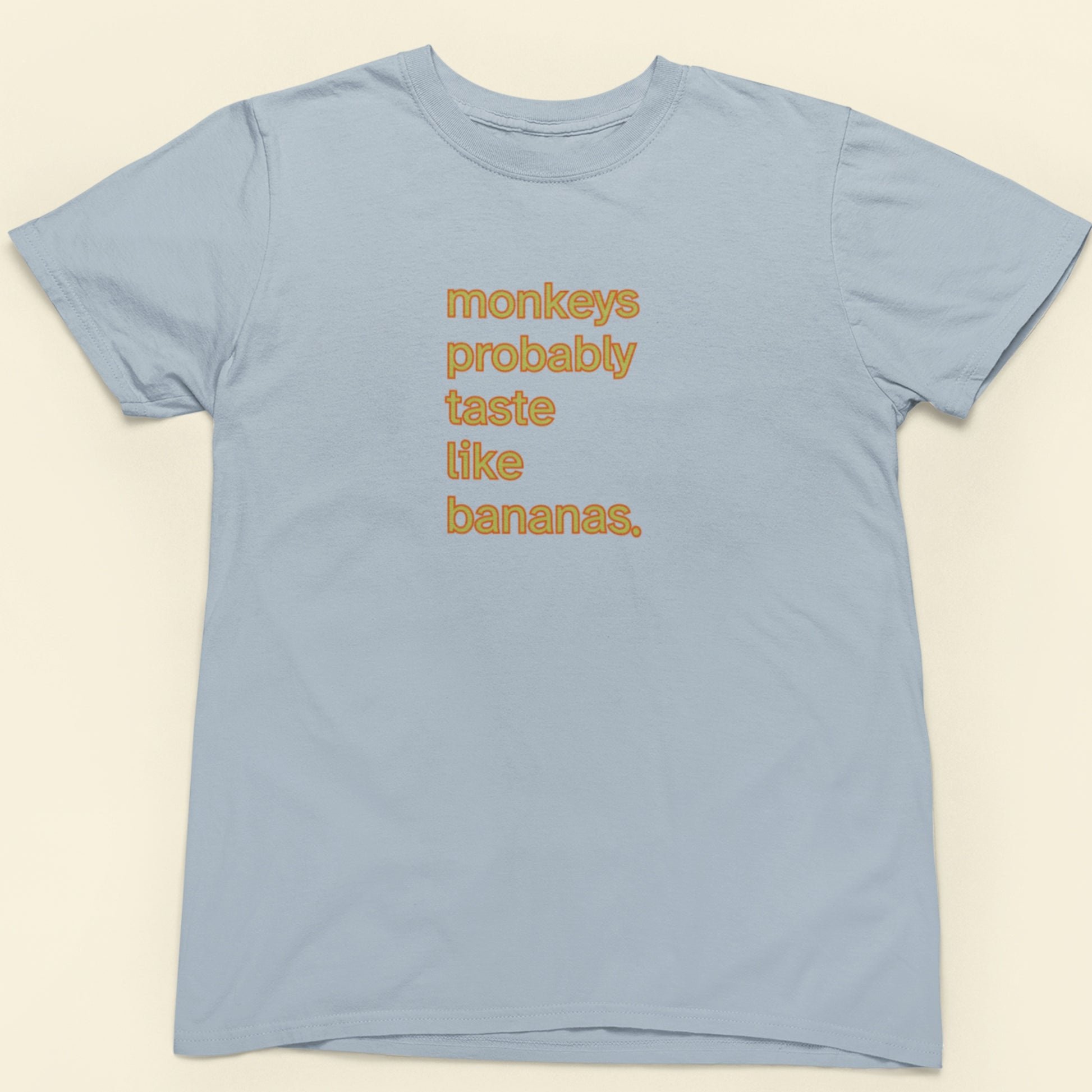 Light blue t-shirt with orange and yellow 'monkeys probably taste like bananas' text.