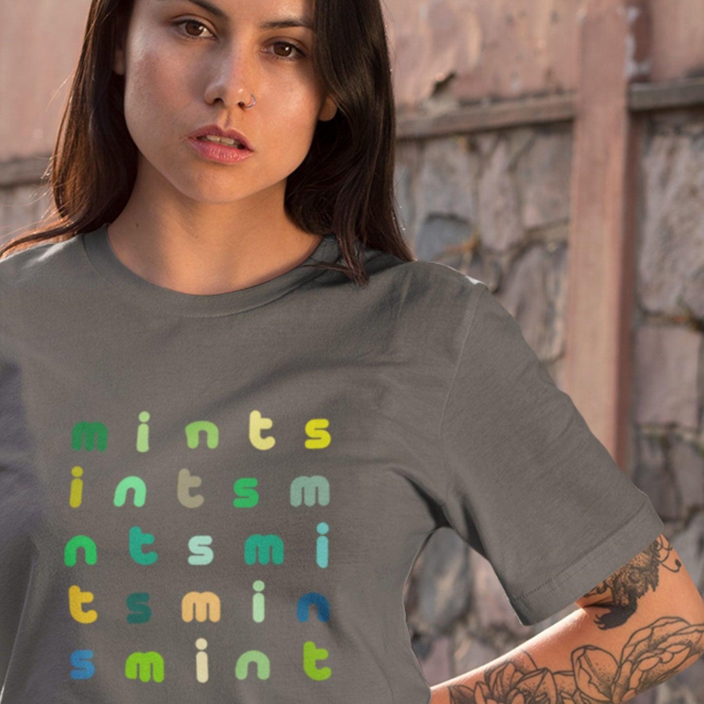 Woman wearing a gray t-shirt with 'mints' text in various colors.