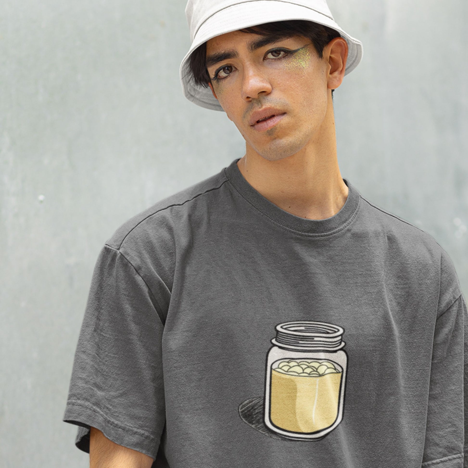 Man wearing a gray t-shirt with a jar design against a plain background.