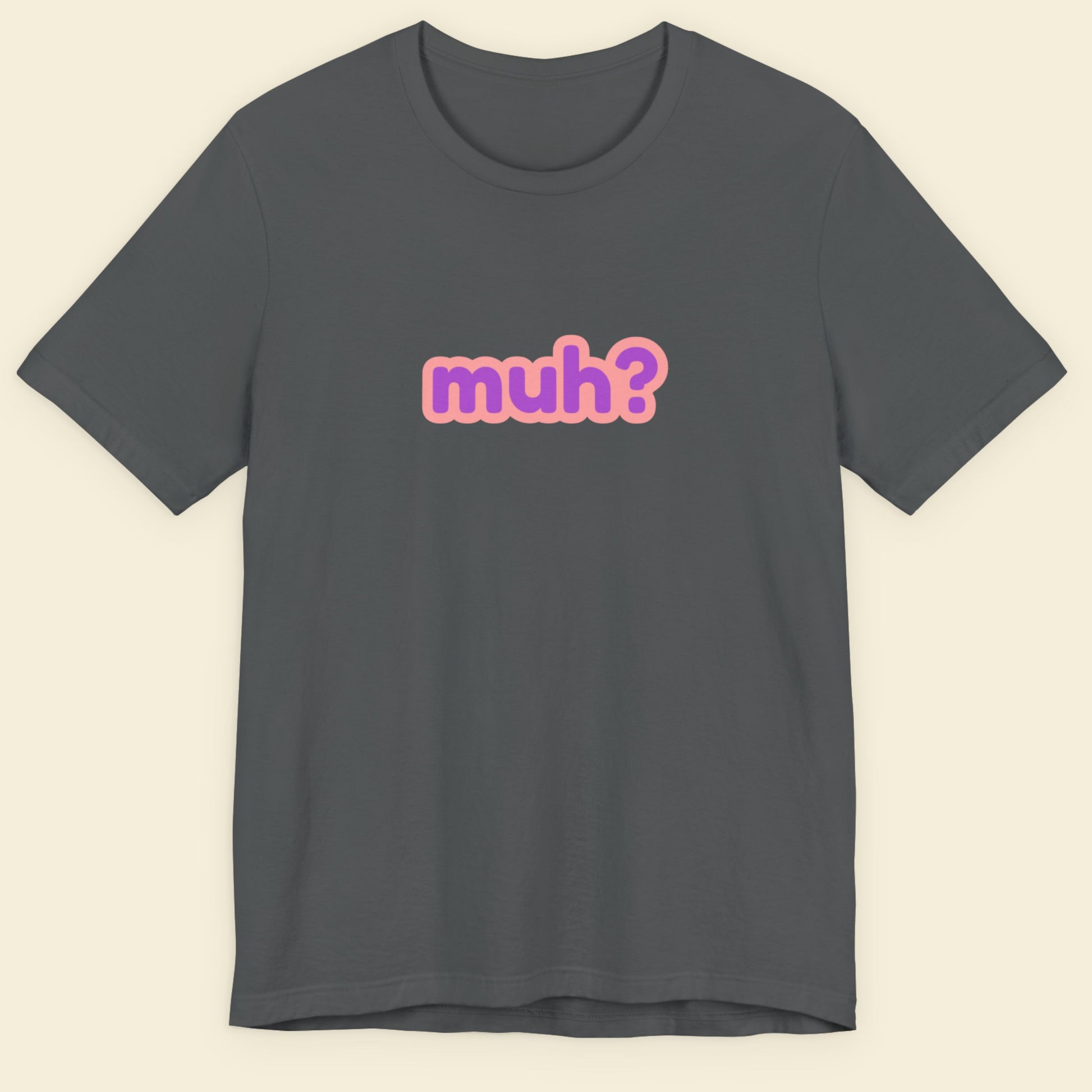 Grey t-shirt with multicolored 'muh?' text on a beige background.