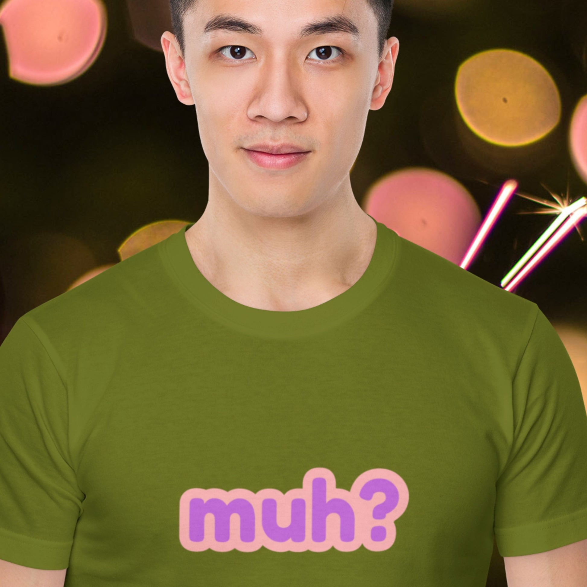Mysterious man wearing a green t-shirt with multicolored 'muh?' text in front of fireworks or something.