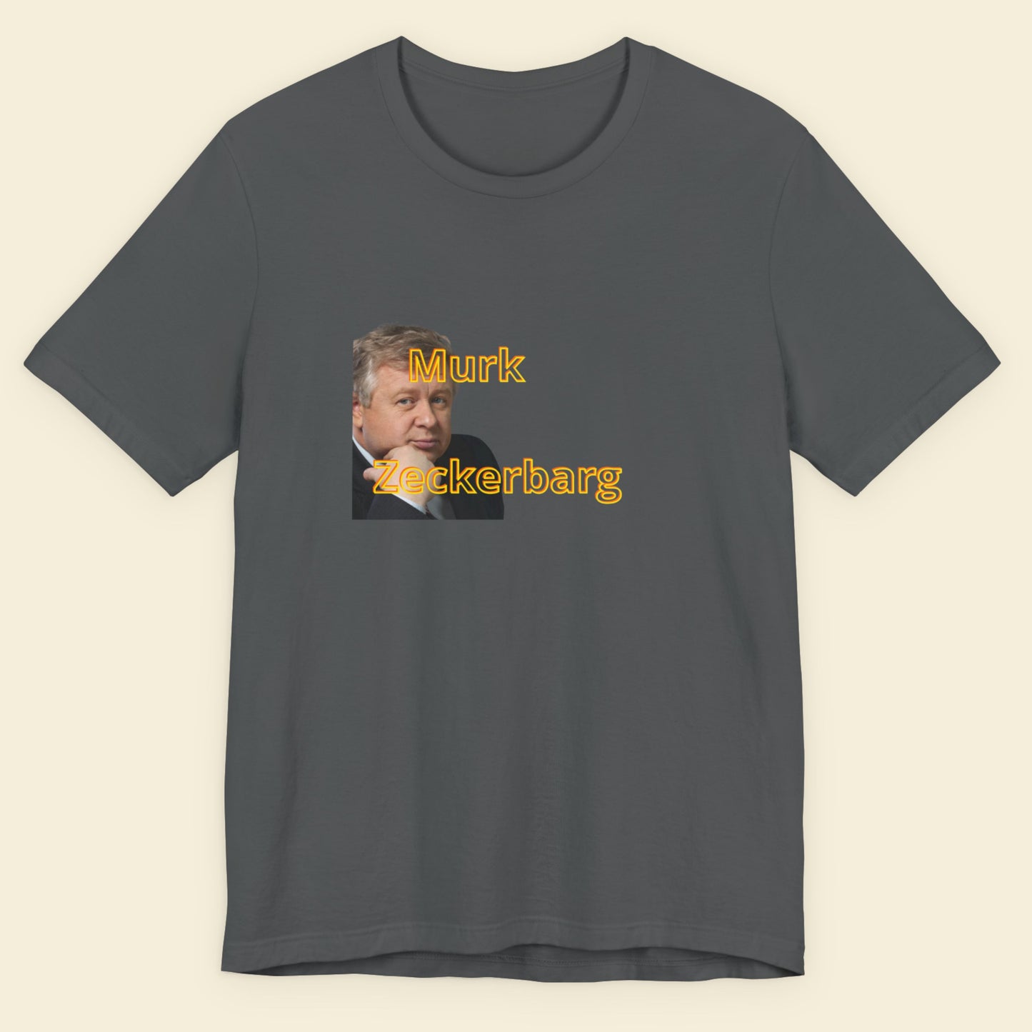 Gray t-shirt with a graphic of a man's face and text 'Murk Zeckerbarg' on a beige background.