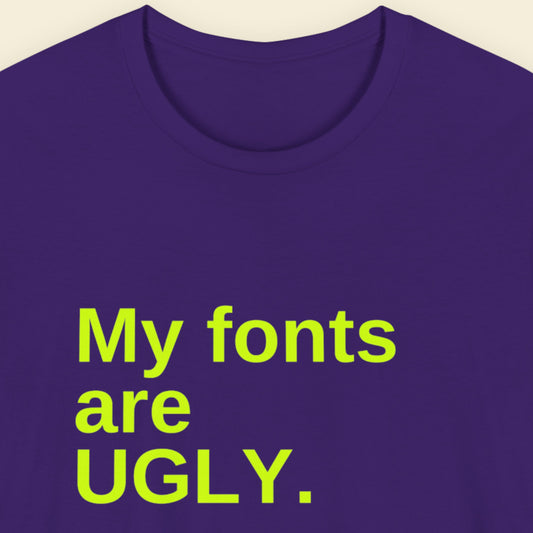 Purple t-shirt with humorous colorful text on a beige background.